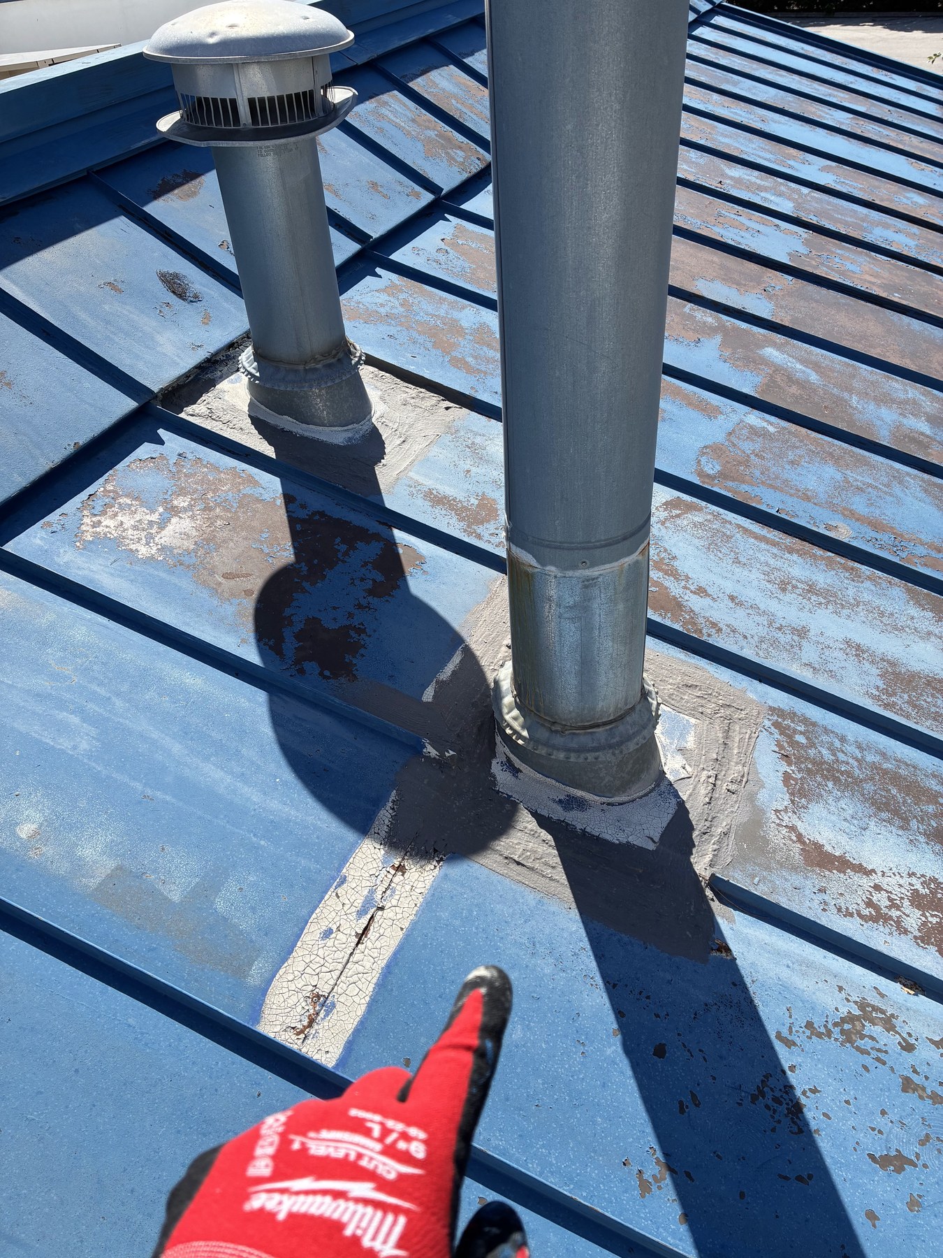 Weathered metal roof around commercial vent stacks