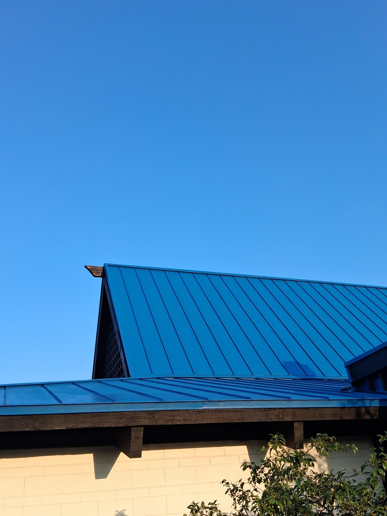 Freshly painted blue metal roof over a commercial exterior