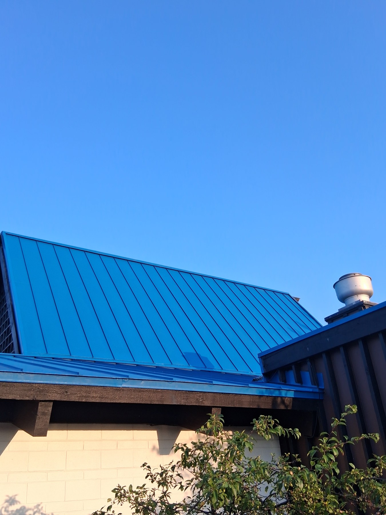 Metal roof finish beneath clear blue skies