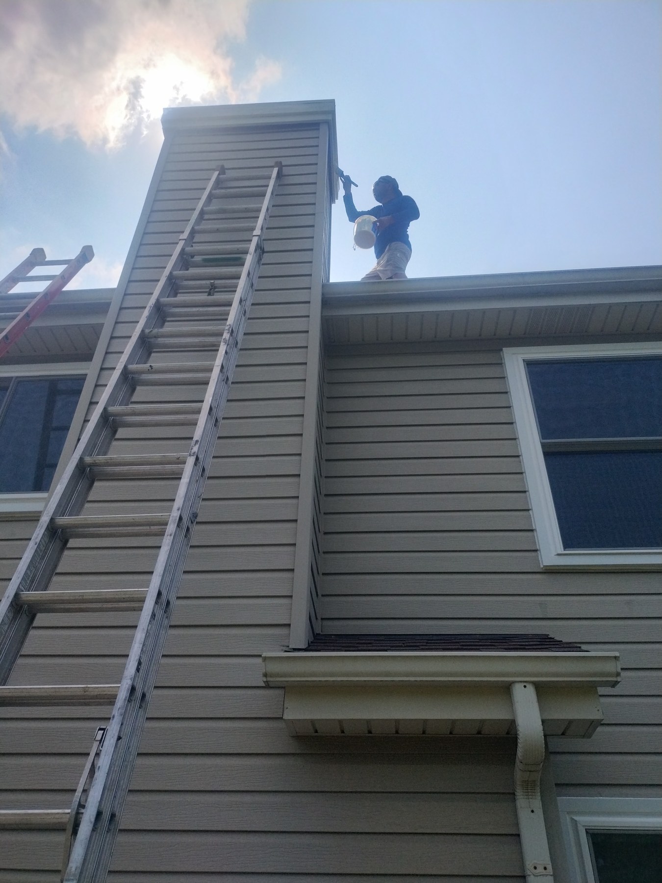 Painter working on upper exterior trim