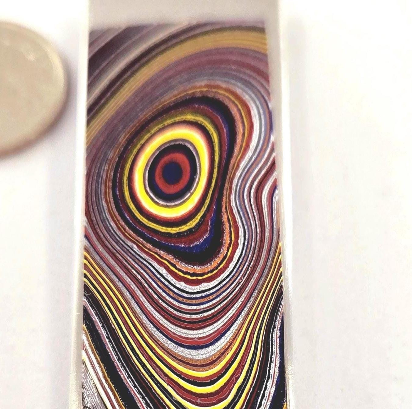 Hand-cut Fordite tie tack with colorful automotive paint layers