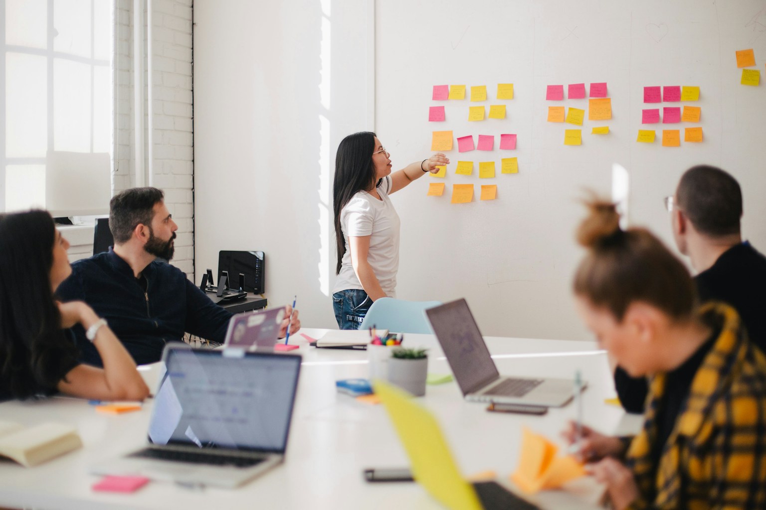 Team planning an event agenda with sticky notes on a whiteboard