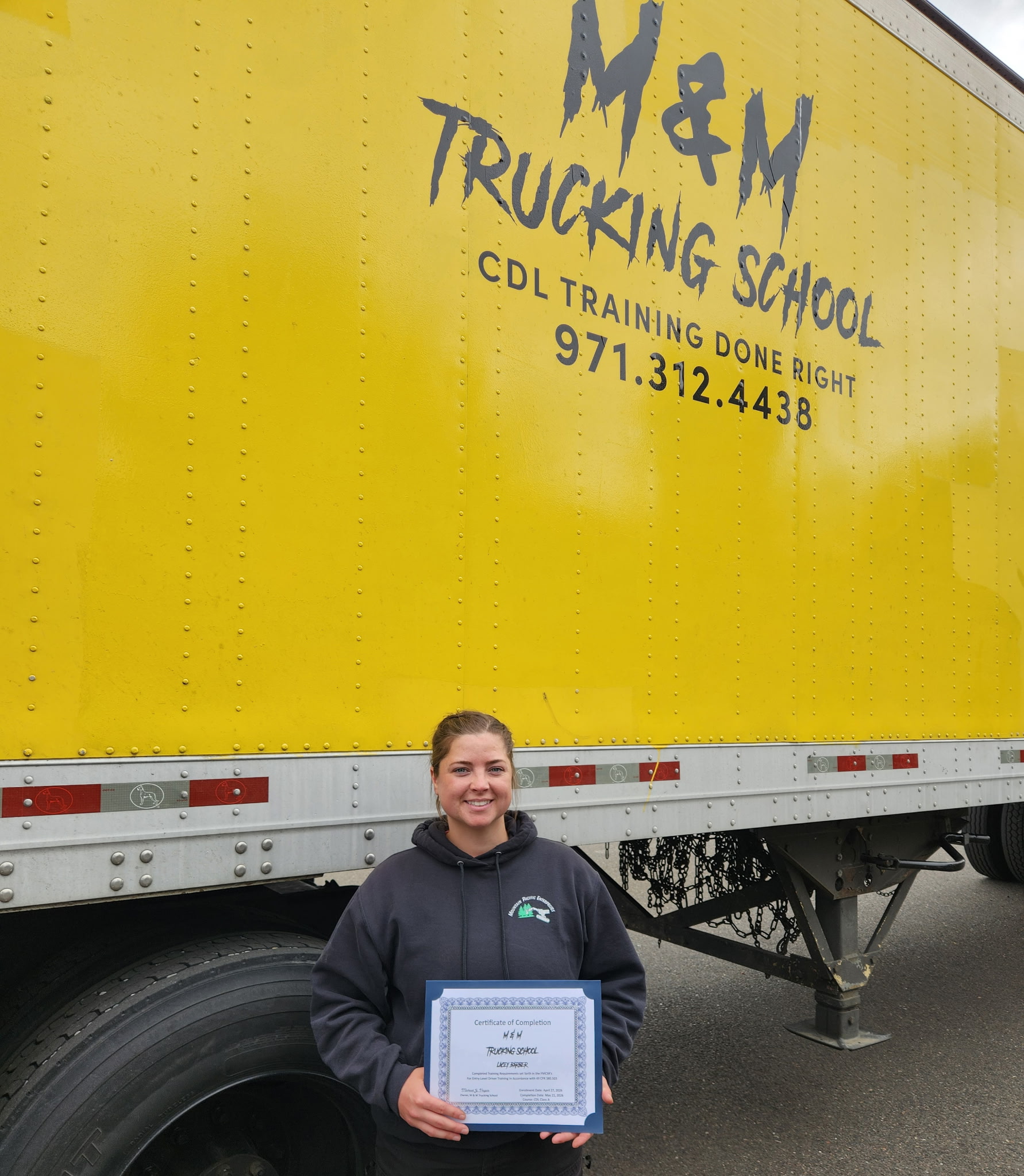 Recent M&M Trucking School graduate beside a commercial truck