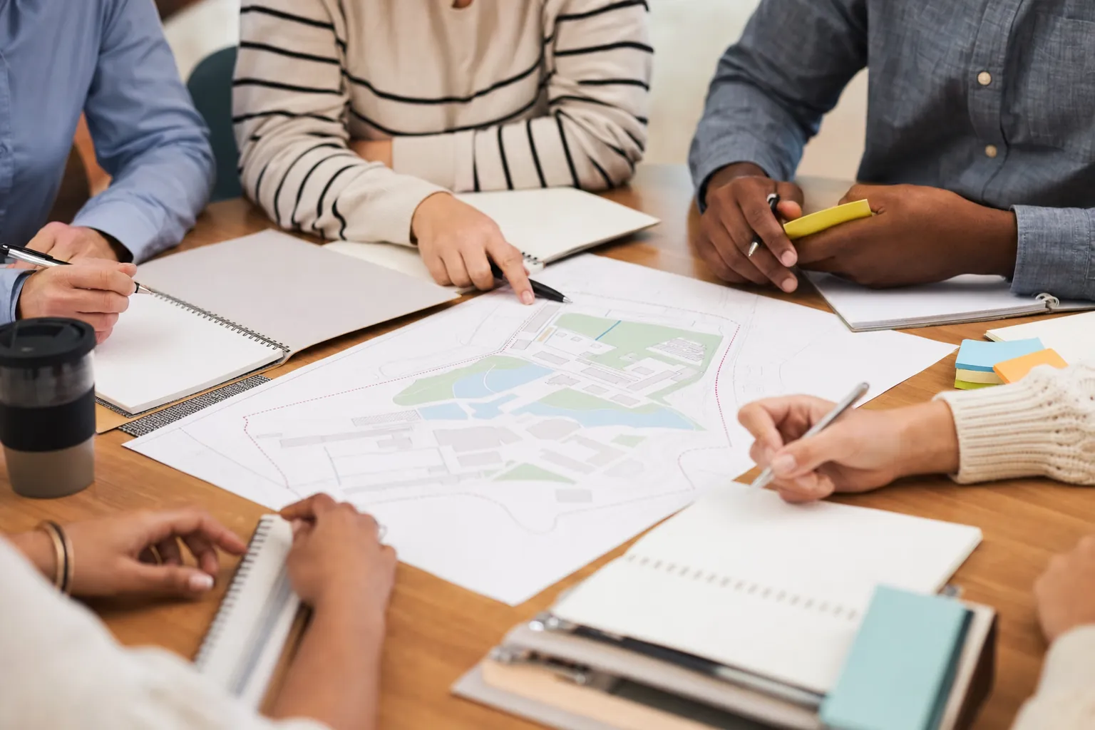 Planning team members gathered around a campus map and notebooks