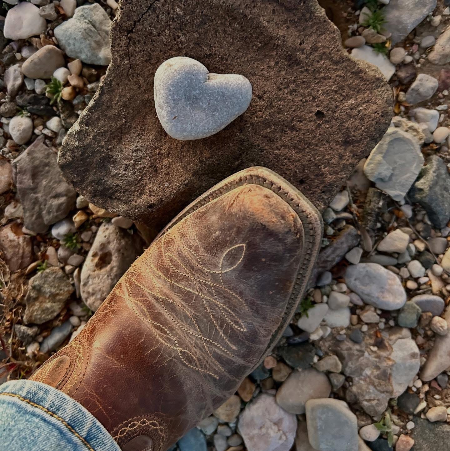 A heart-shaped stone resting on a rock beside Kate’s worn leather boot
