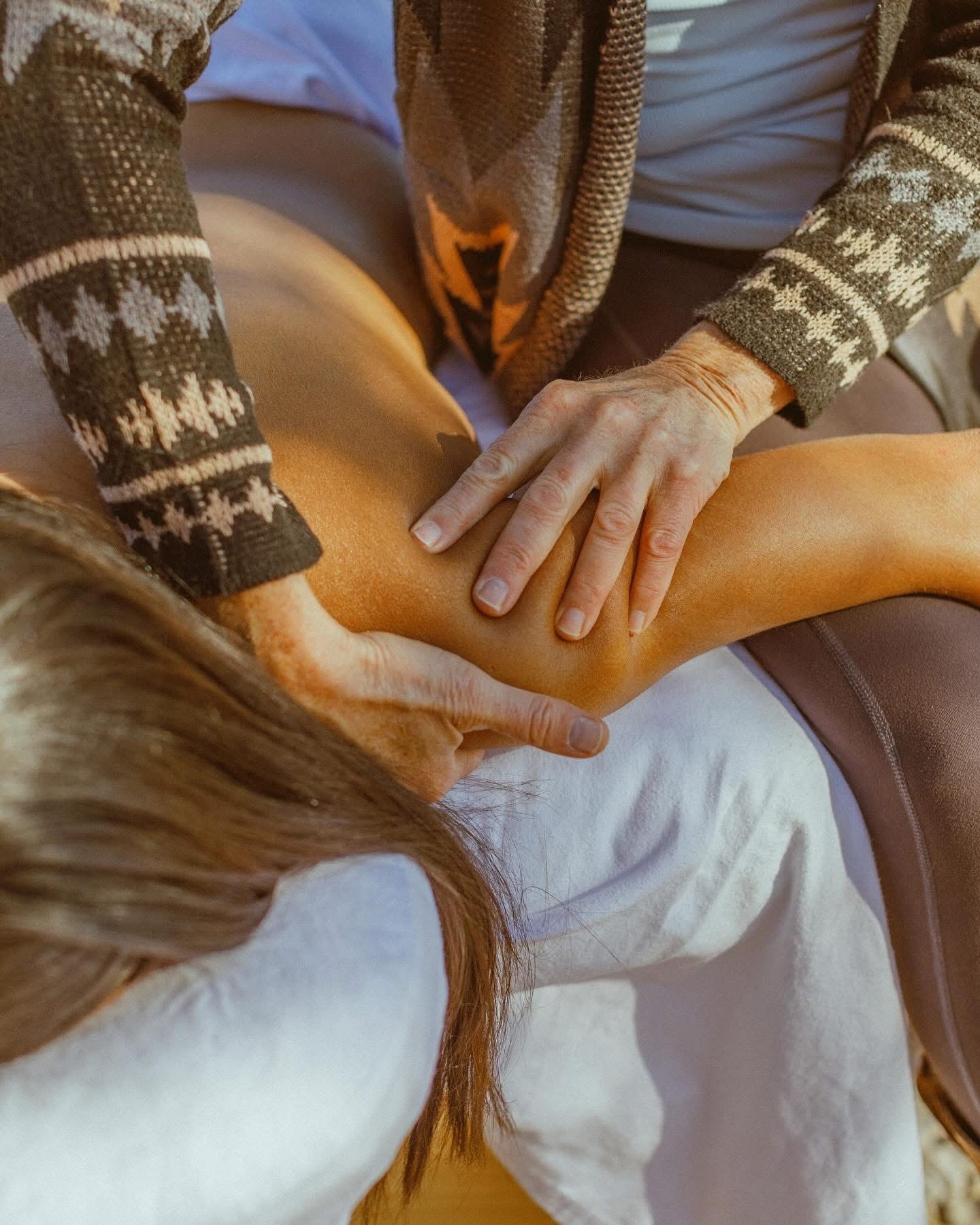Kate Healy, LMT’s hands providing focused bodywork to a client’s shoulder