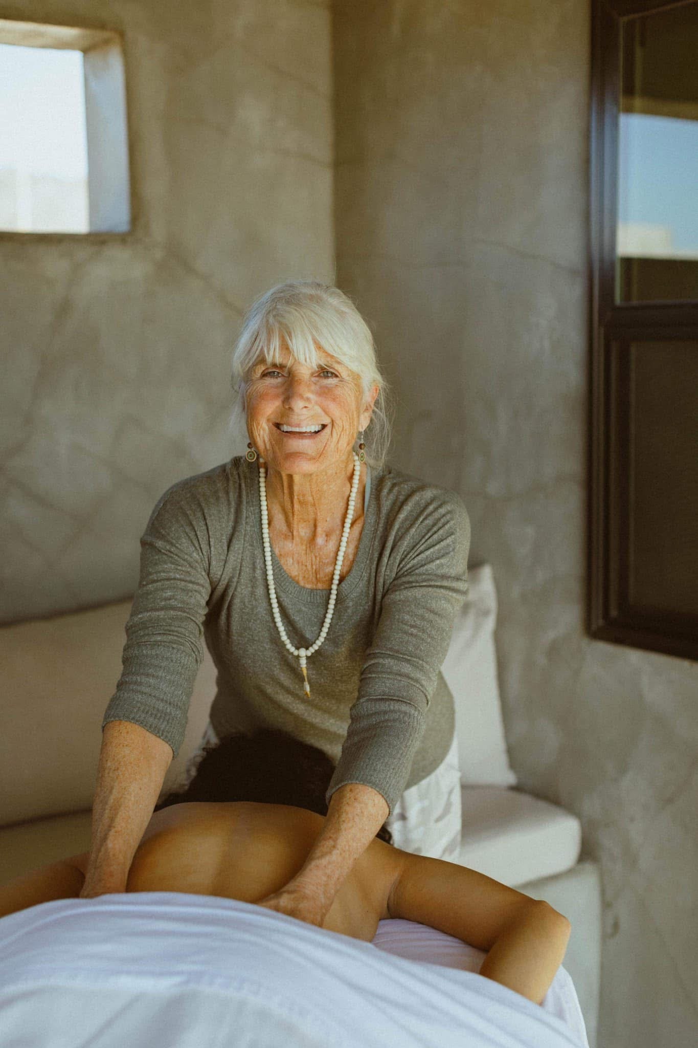 Kate Healy, LMT smiling while giving a client a massage