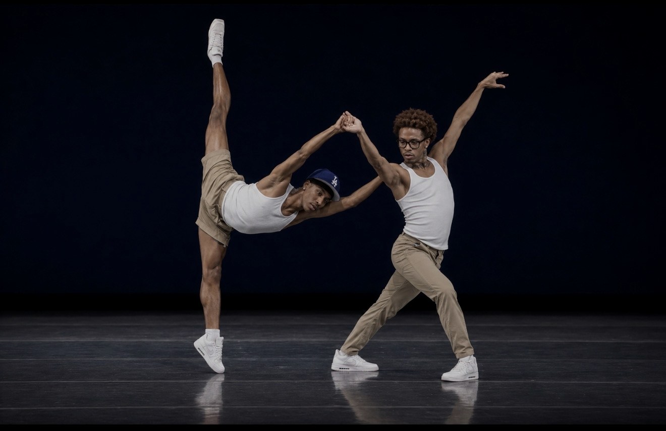 Two dancers performing a high extension on stage