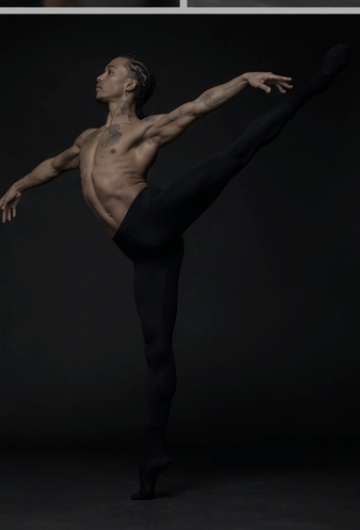 Dancer holding a high kick against a dark background