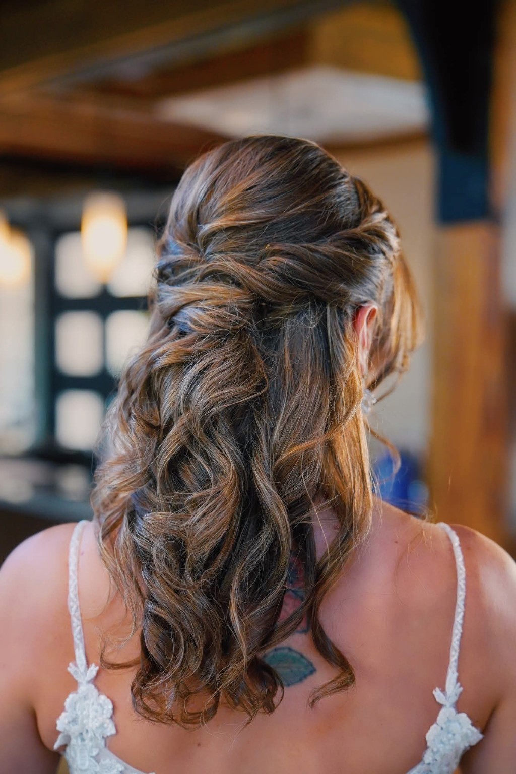 Romantic brunette half-up bridal hairstyle with softly cascading curls