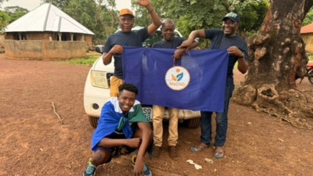 Volunteers holding the MaCHO flag