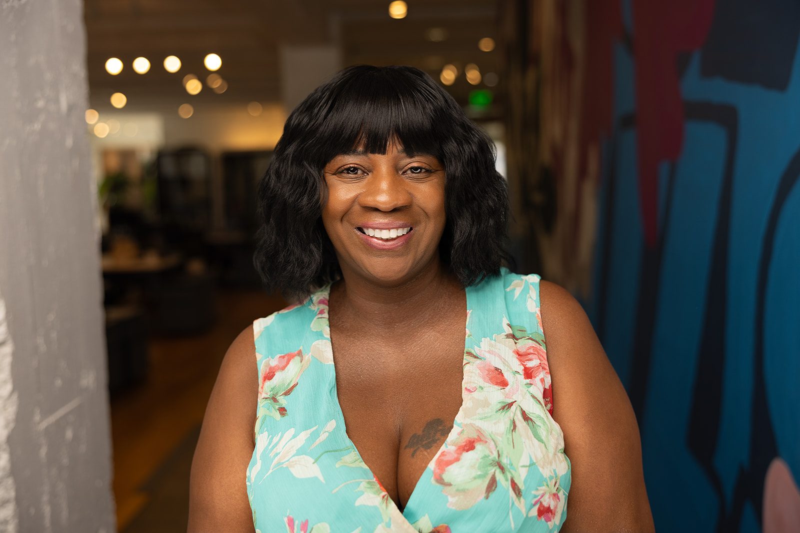 Tamika smiling in a floral dress