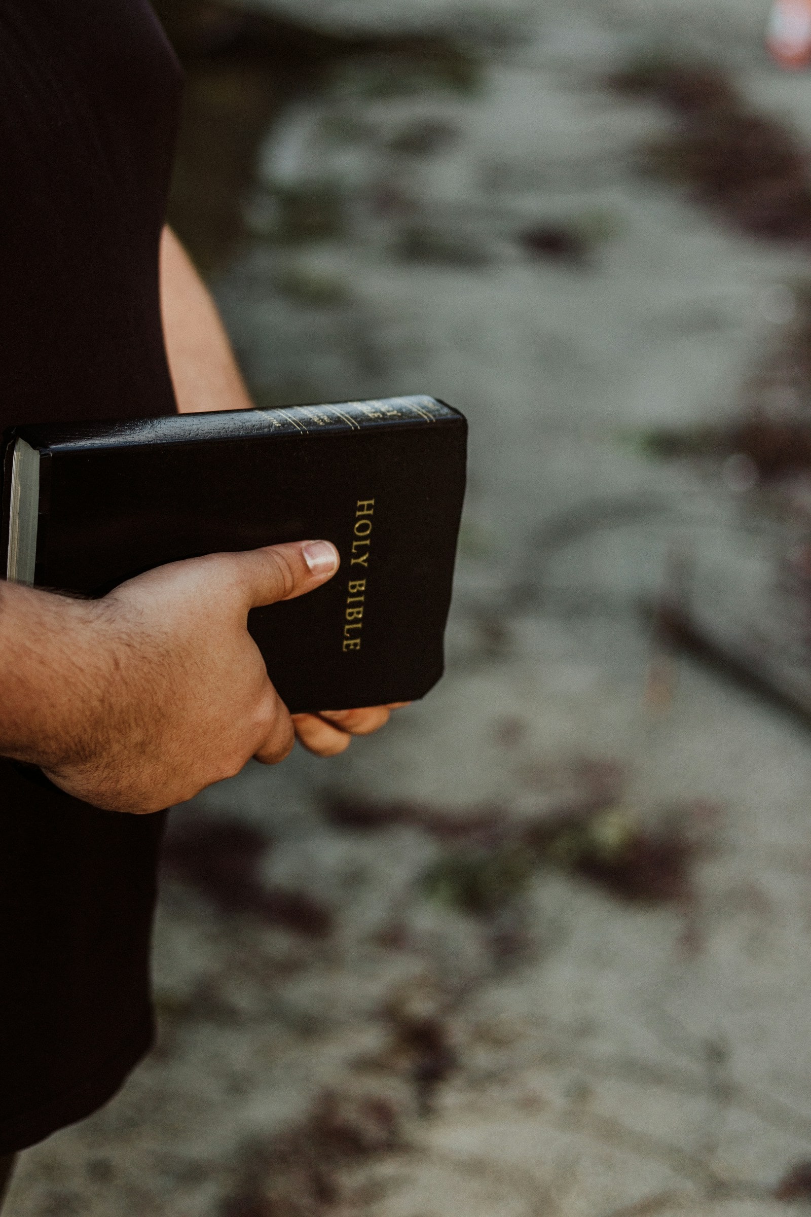 Person holding a black Bible