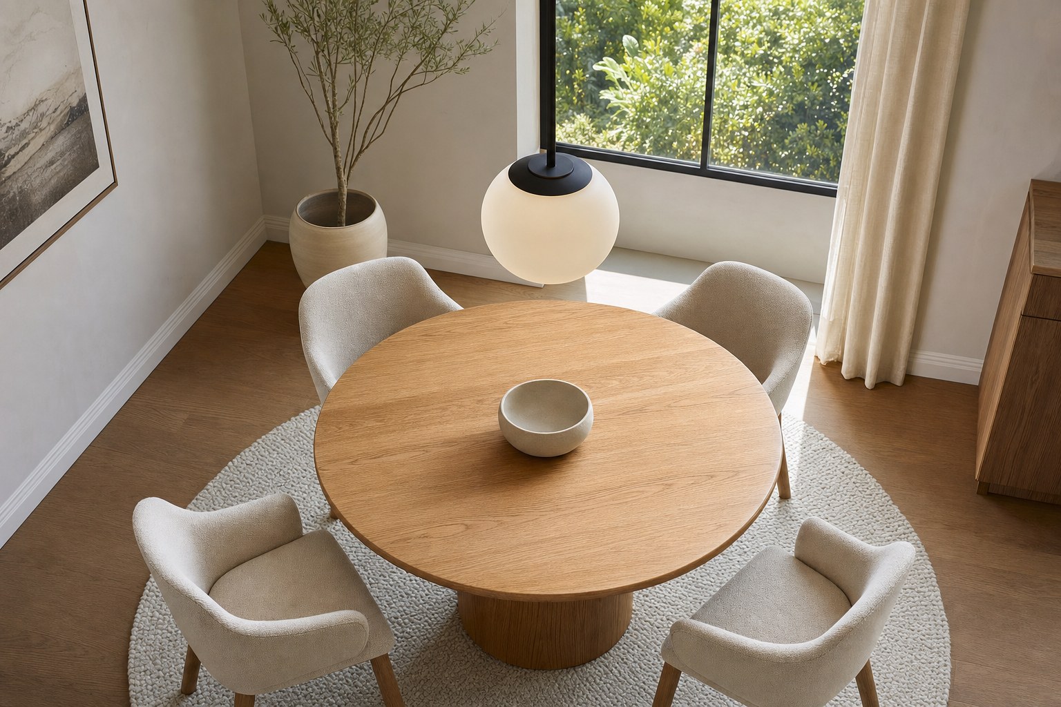 Round oak dining table with one globe pendant centered above it