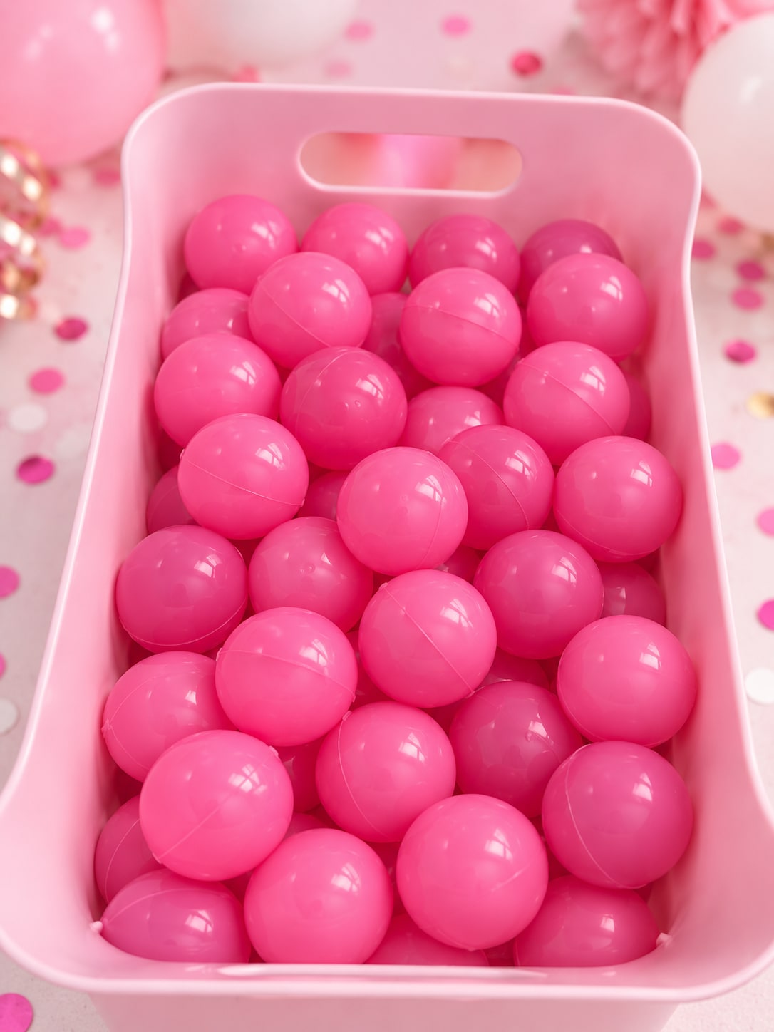 Hot pink ball game balls in a bin