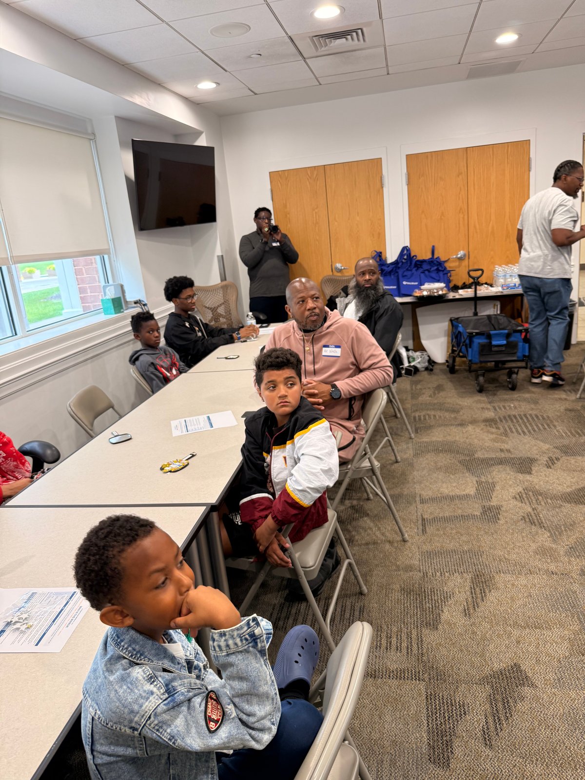 Young men and adults seated around tables at the October S.H.I.E.L.D.S. Meetup