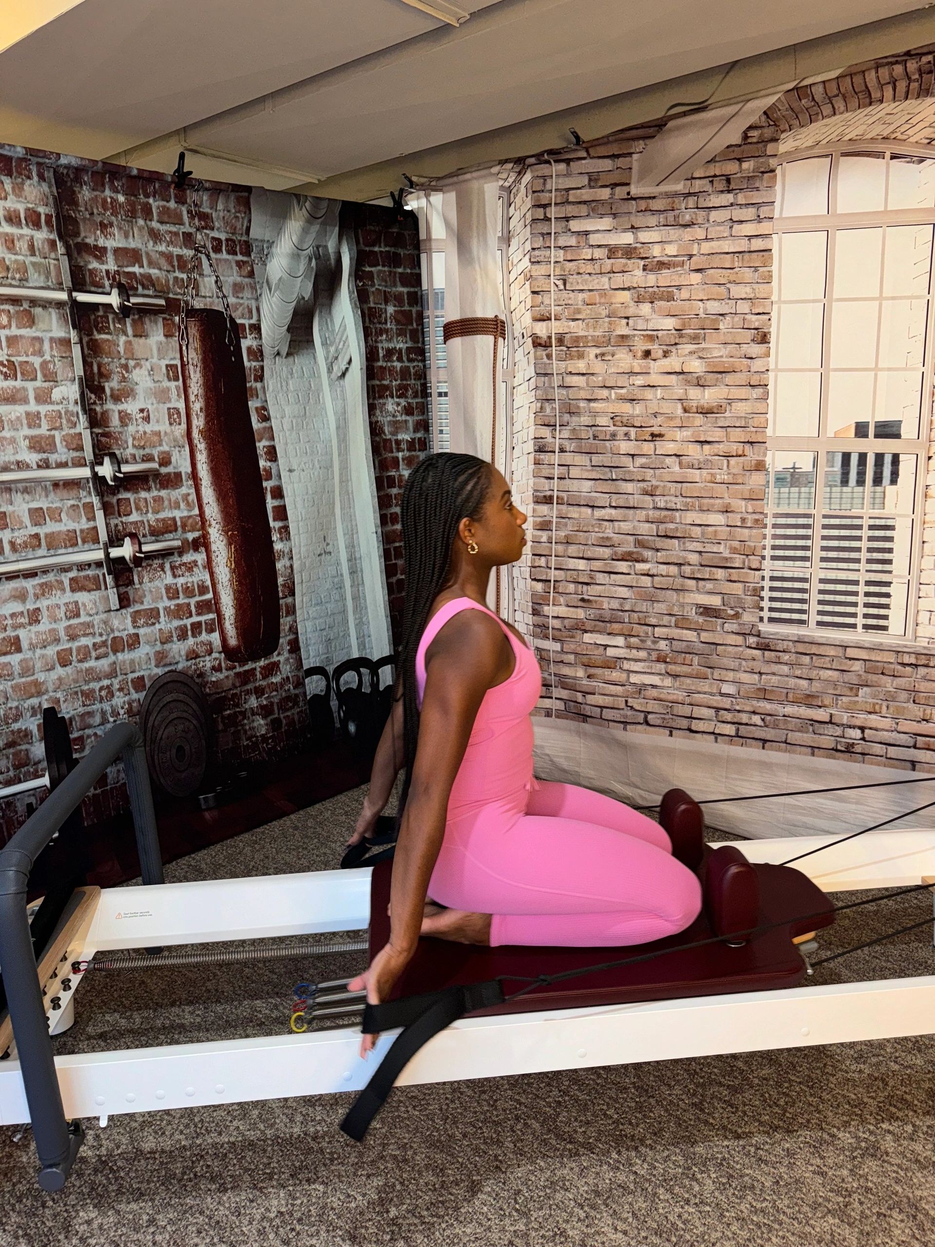 Nicole performing a kneeling Pilates reformer exercise