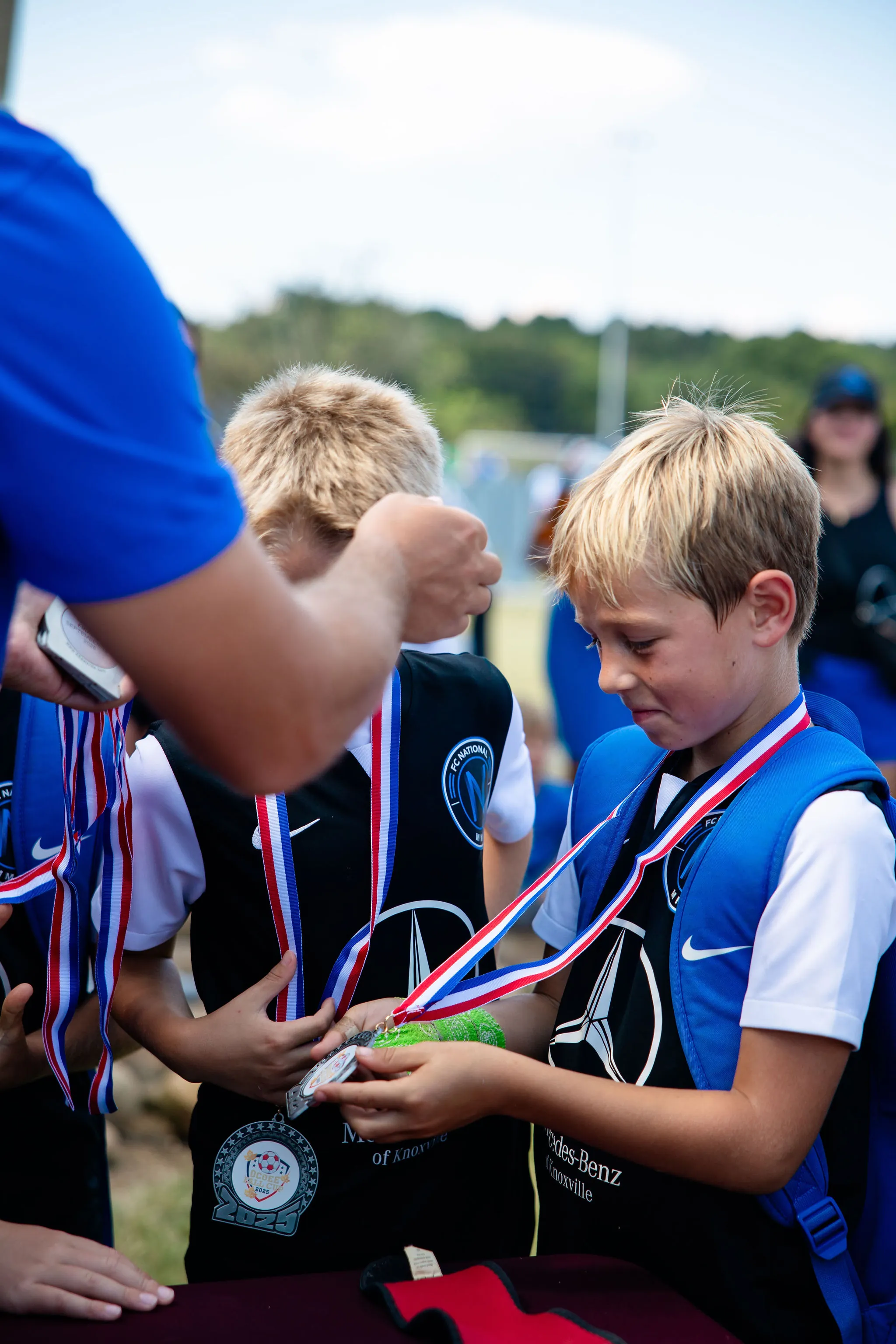FC National players sharing a medal moment after a soccer event