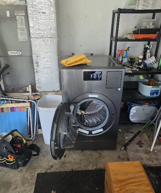 Dryer being serviced in a home laundry room