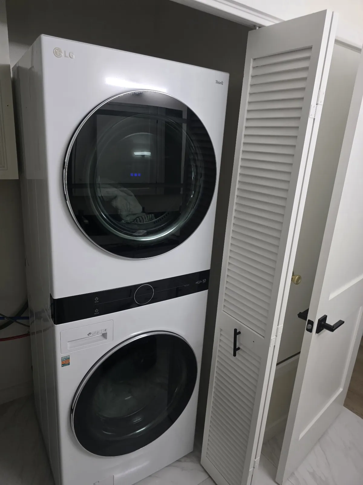 Full-size laundry tower with a washer below and dryer above