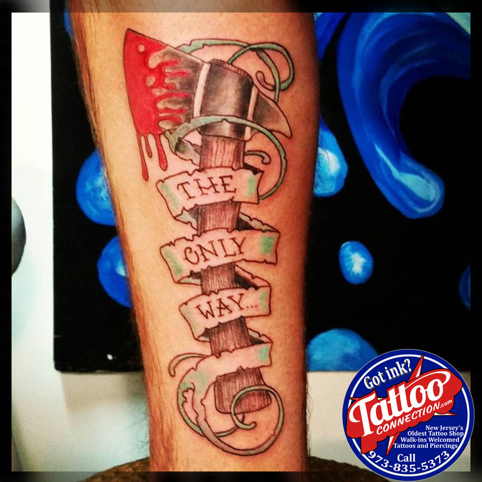 Bloody hatchet and banner tattoo by Joe Kennedy