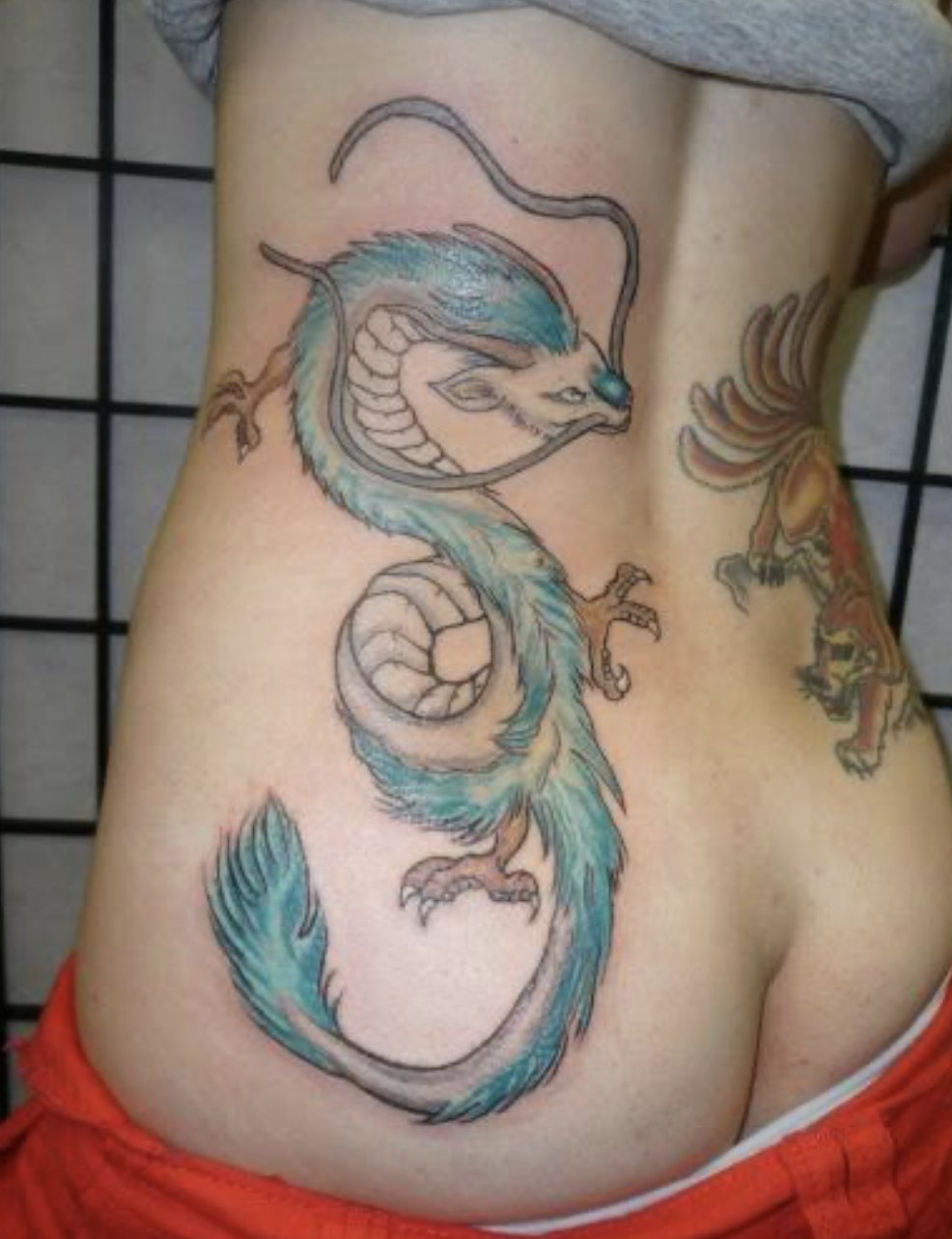 Colorful sea serpent torso tattoo by Joe Kennedy