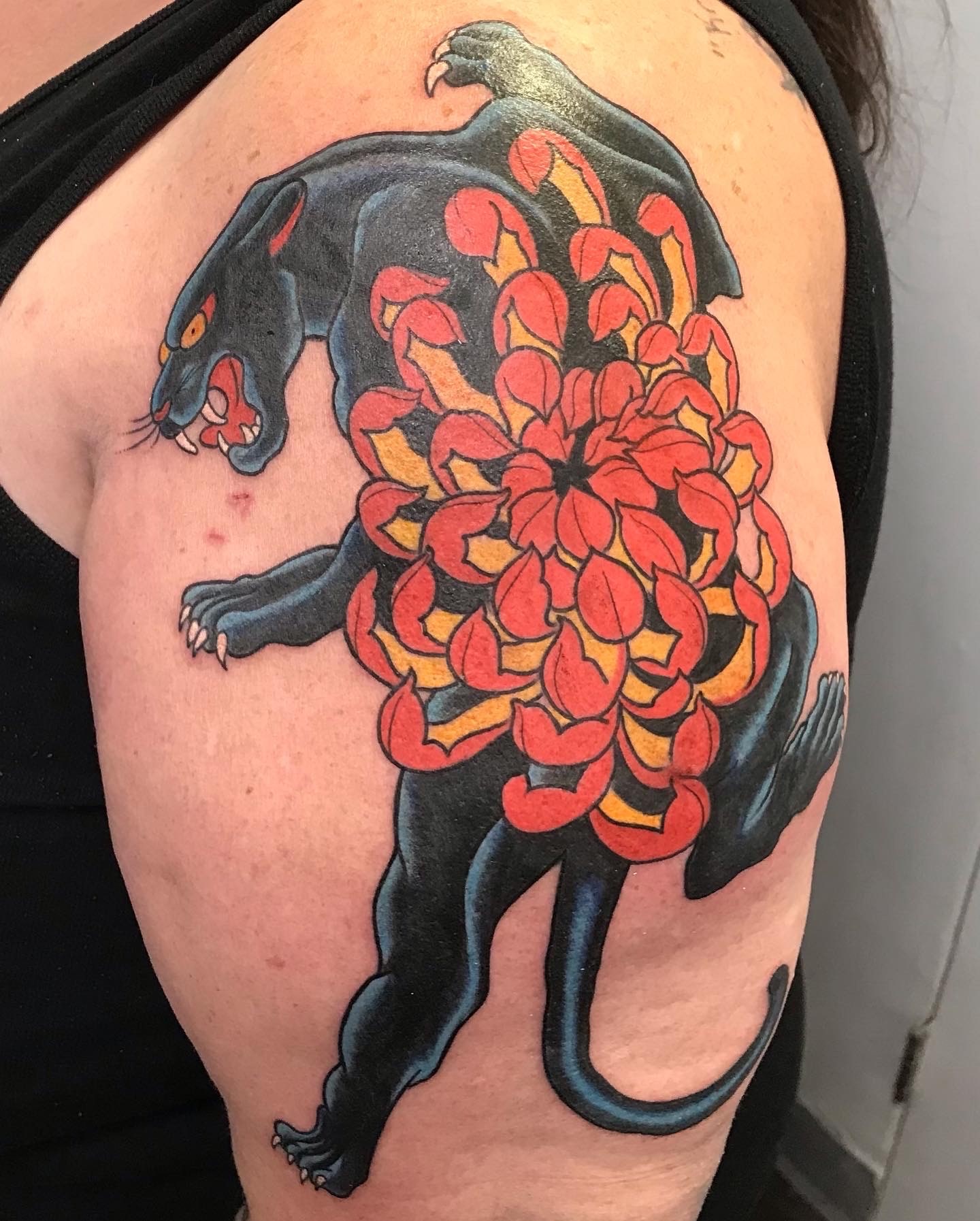 Black panther and red flowers tattoo by Rob Scotti