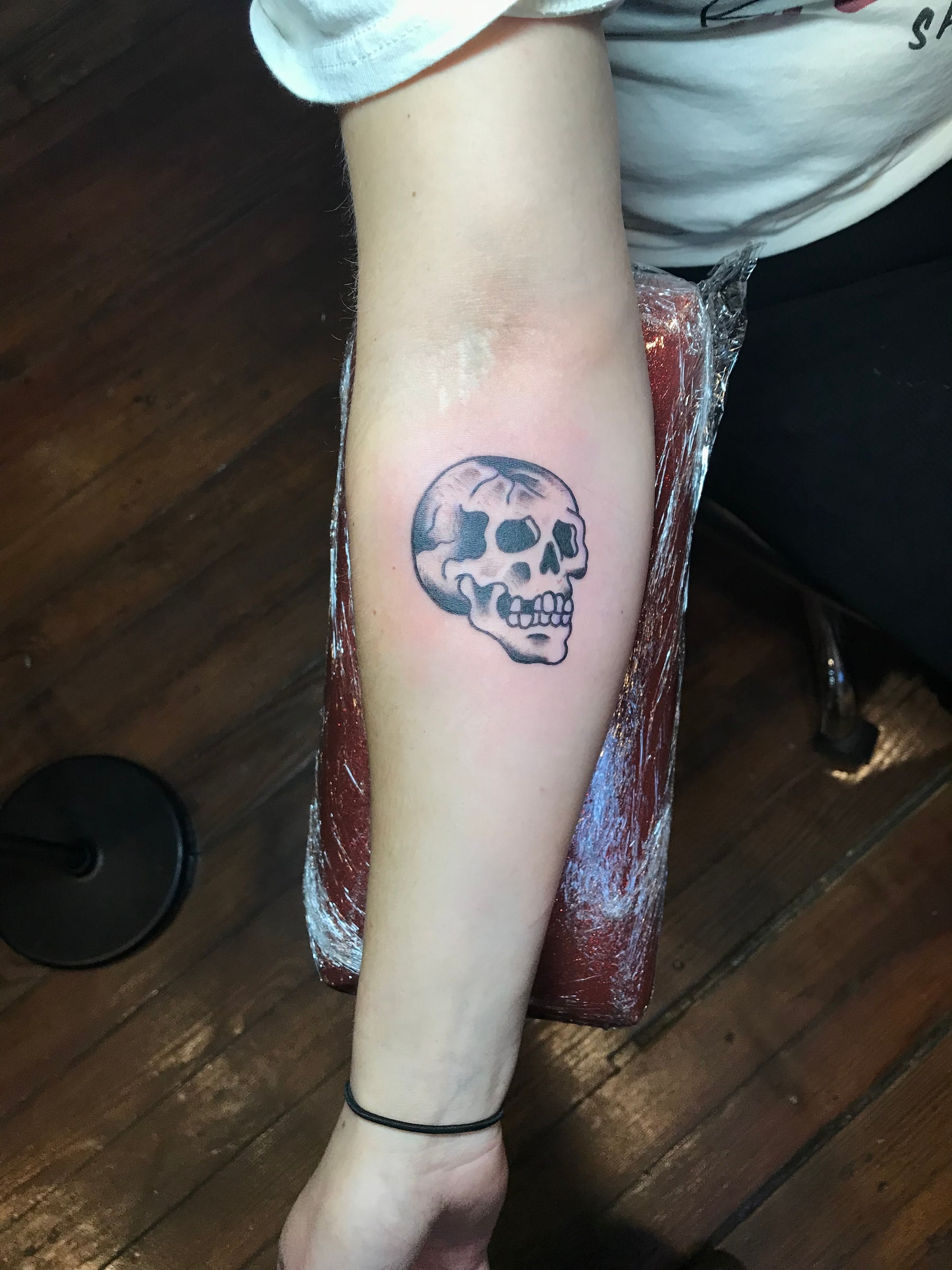Black and gray skull forearm tattoo by Rob Scotti