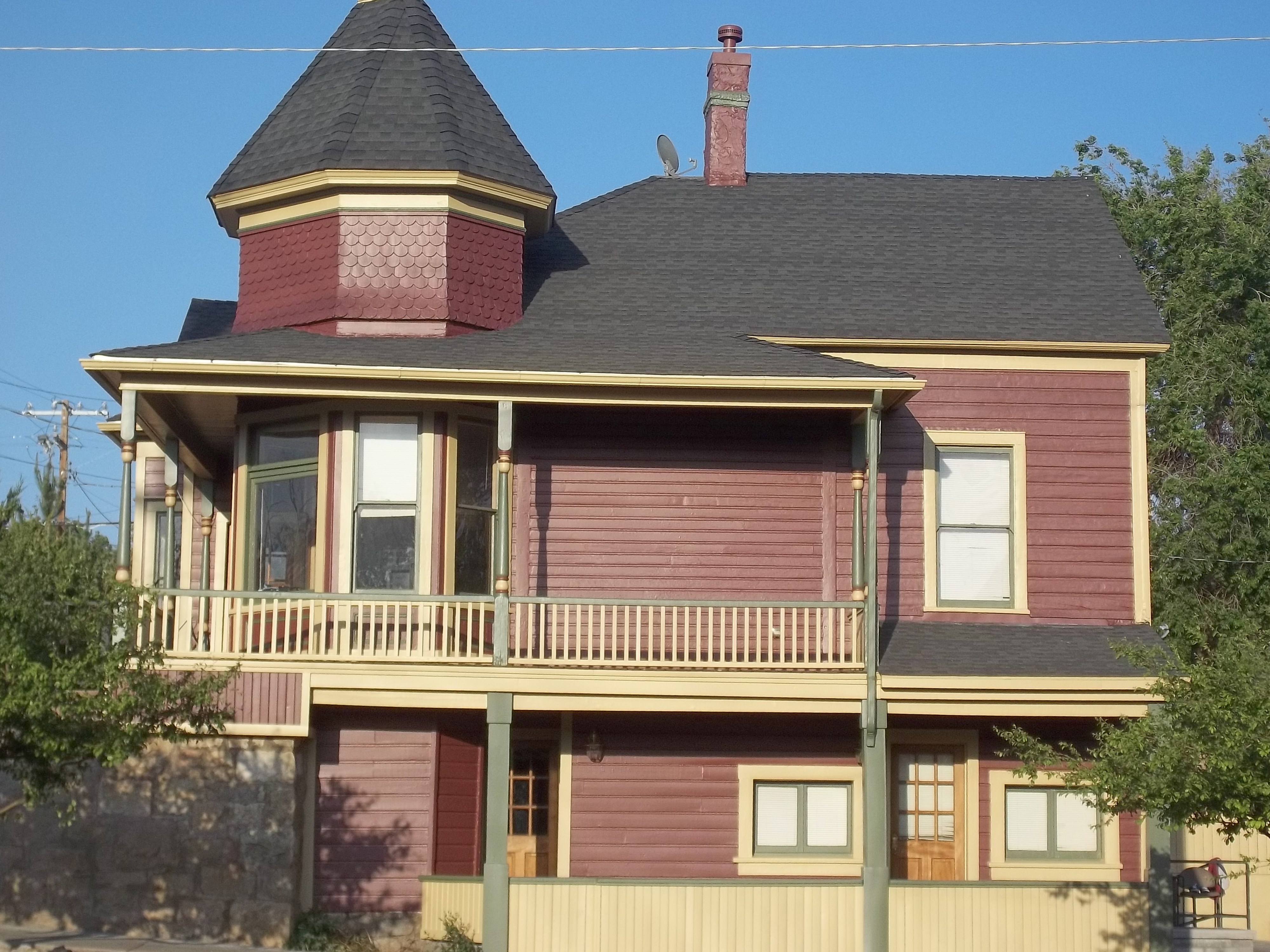 Completed historic home exterior with wraparound porch and turret