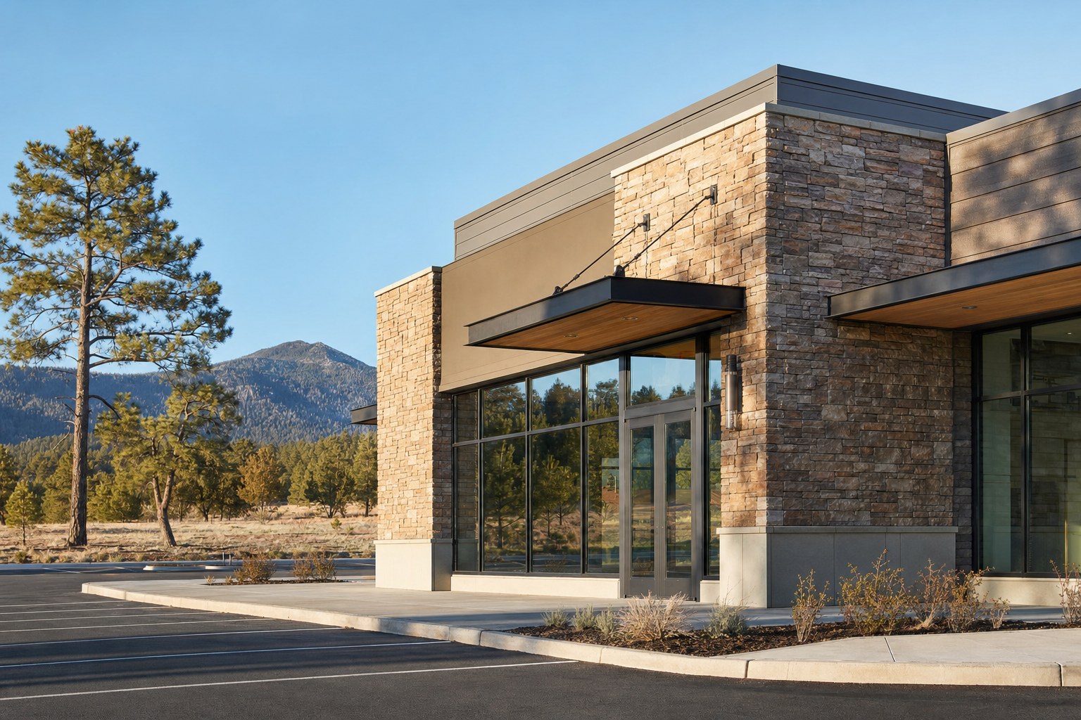 Completed Northern Arizona retail storefront with natural stone, storefront glass, and mountain views