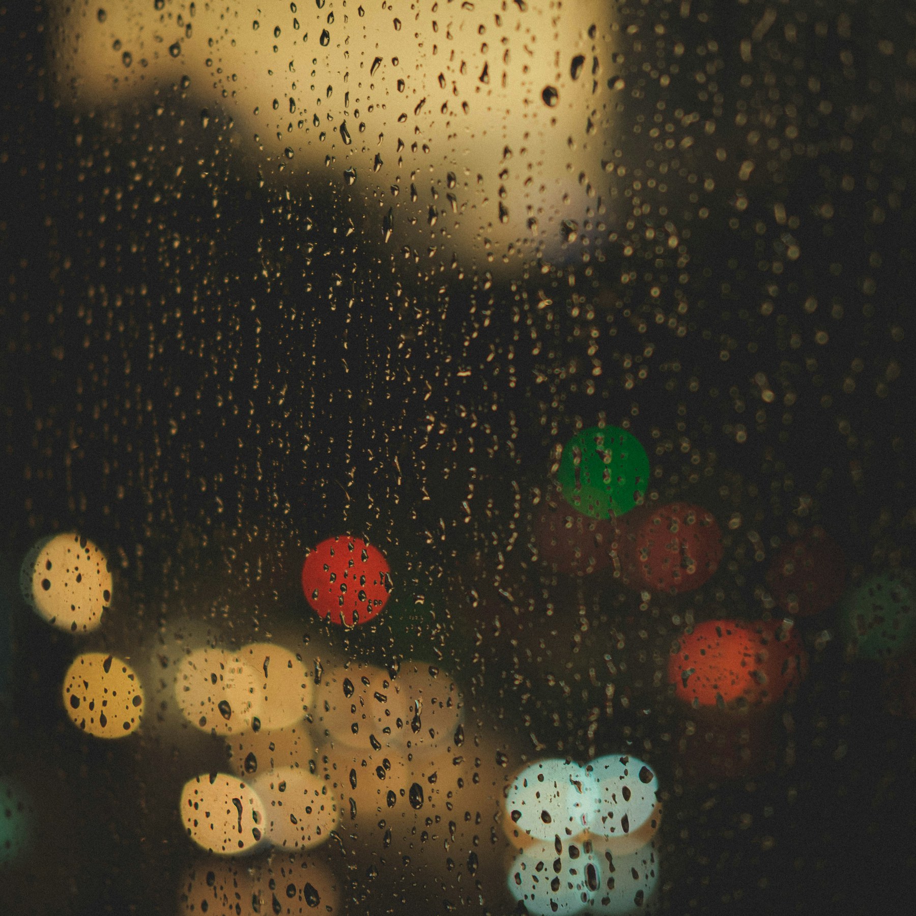 Rain drops on a window with distant city lights