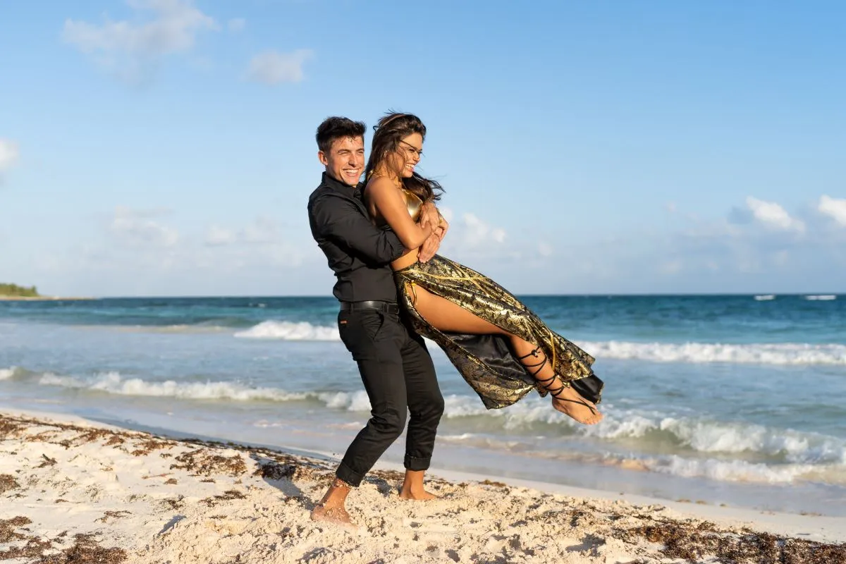 Engaged couple celebrating together on a beach