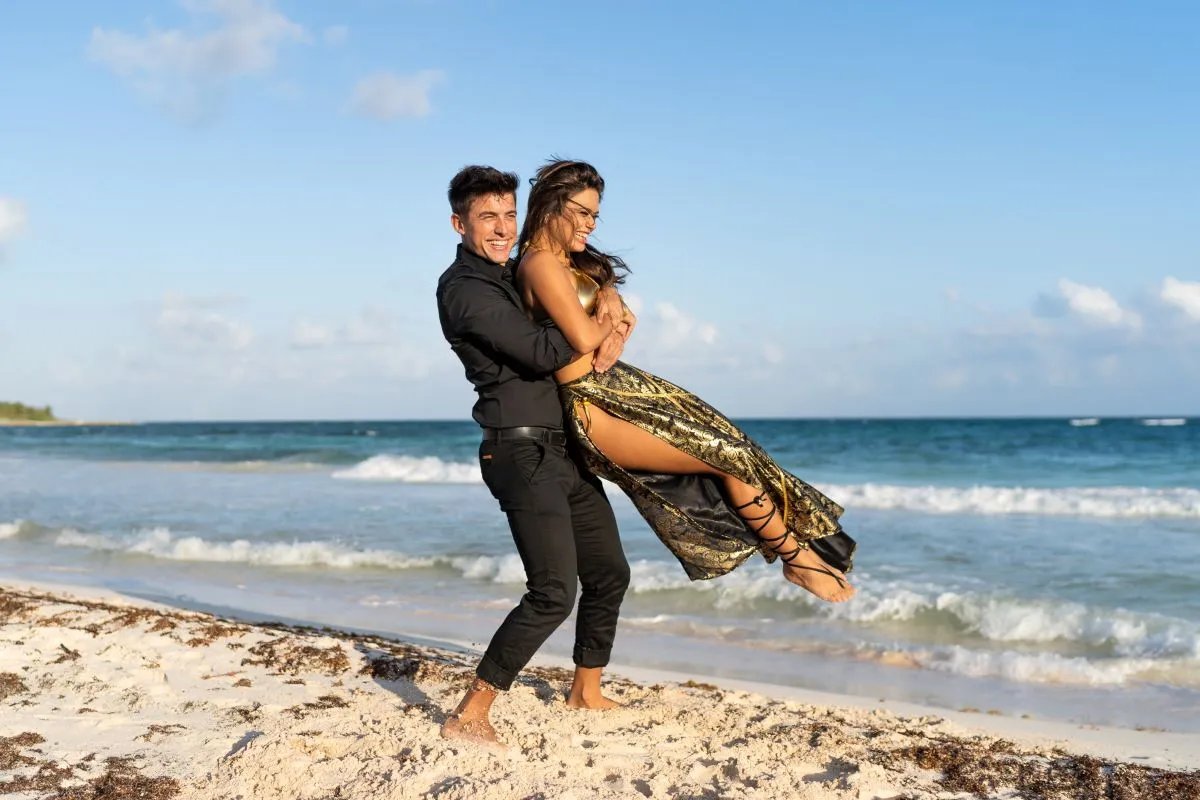 Engaged couple celebrating together on a beach