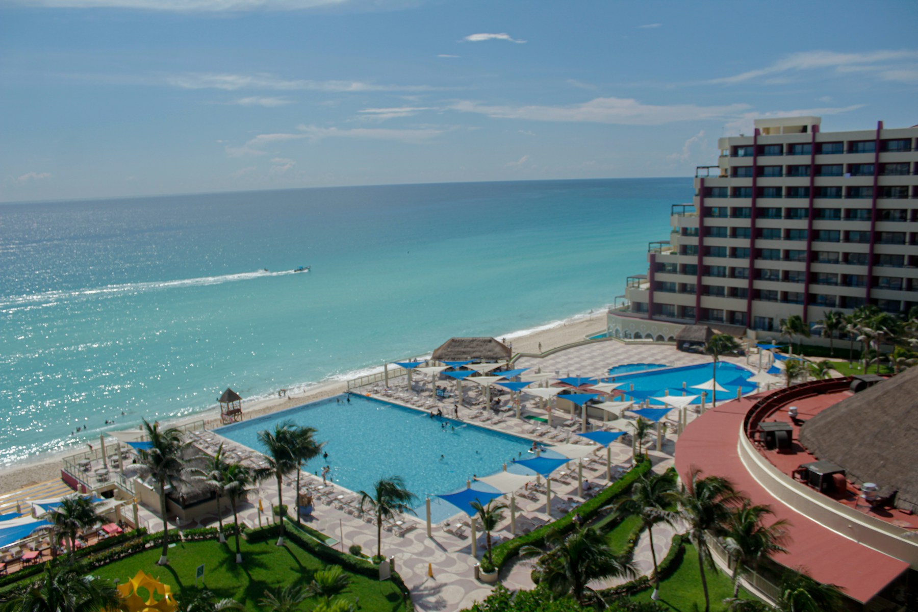 Beachfront resort pool and turquoise Caribbean water in Cancun