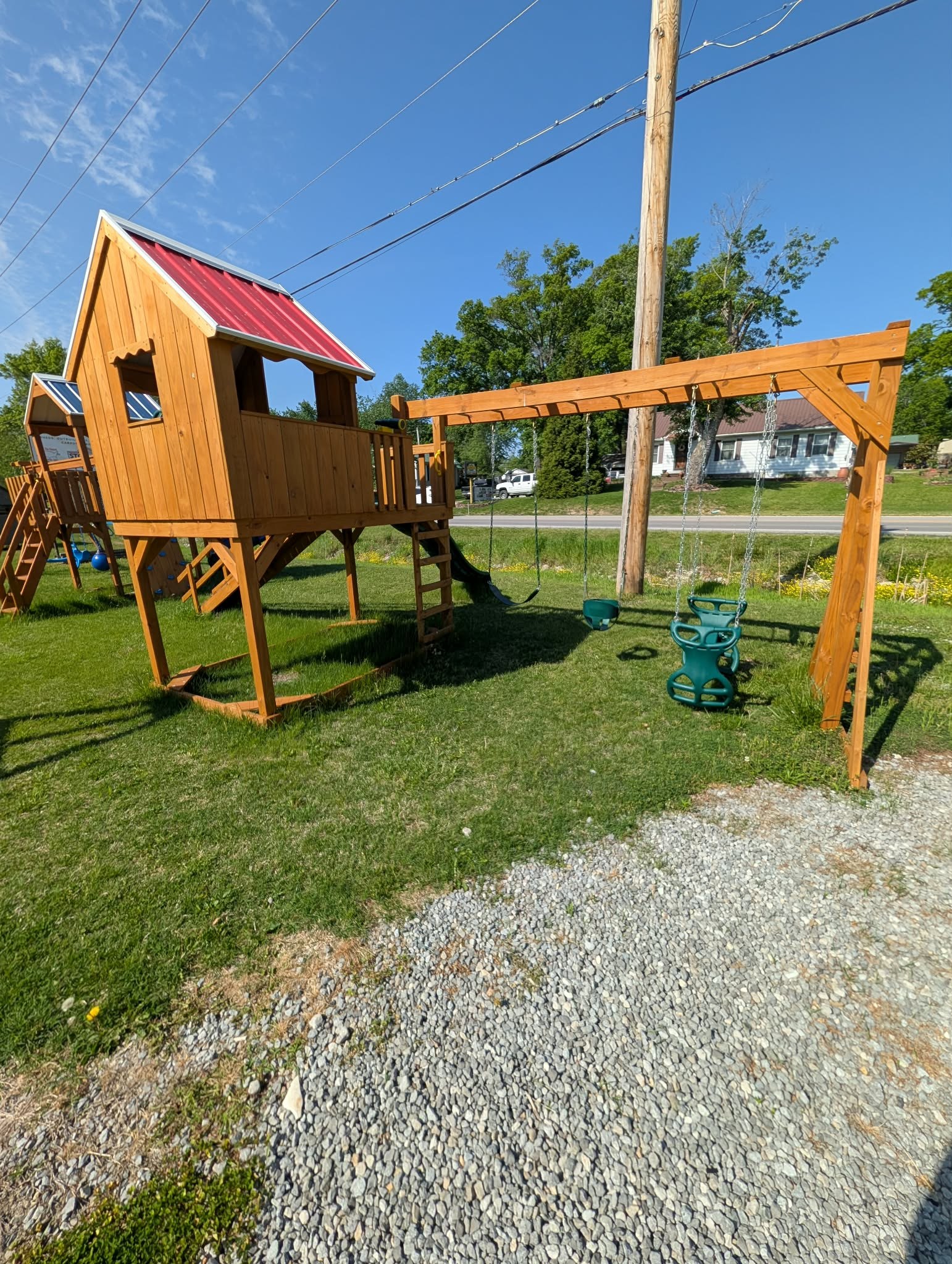 Wooden playset with covered tower, slide, and swings
