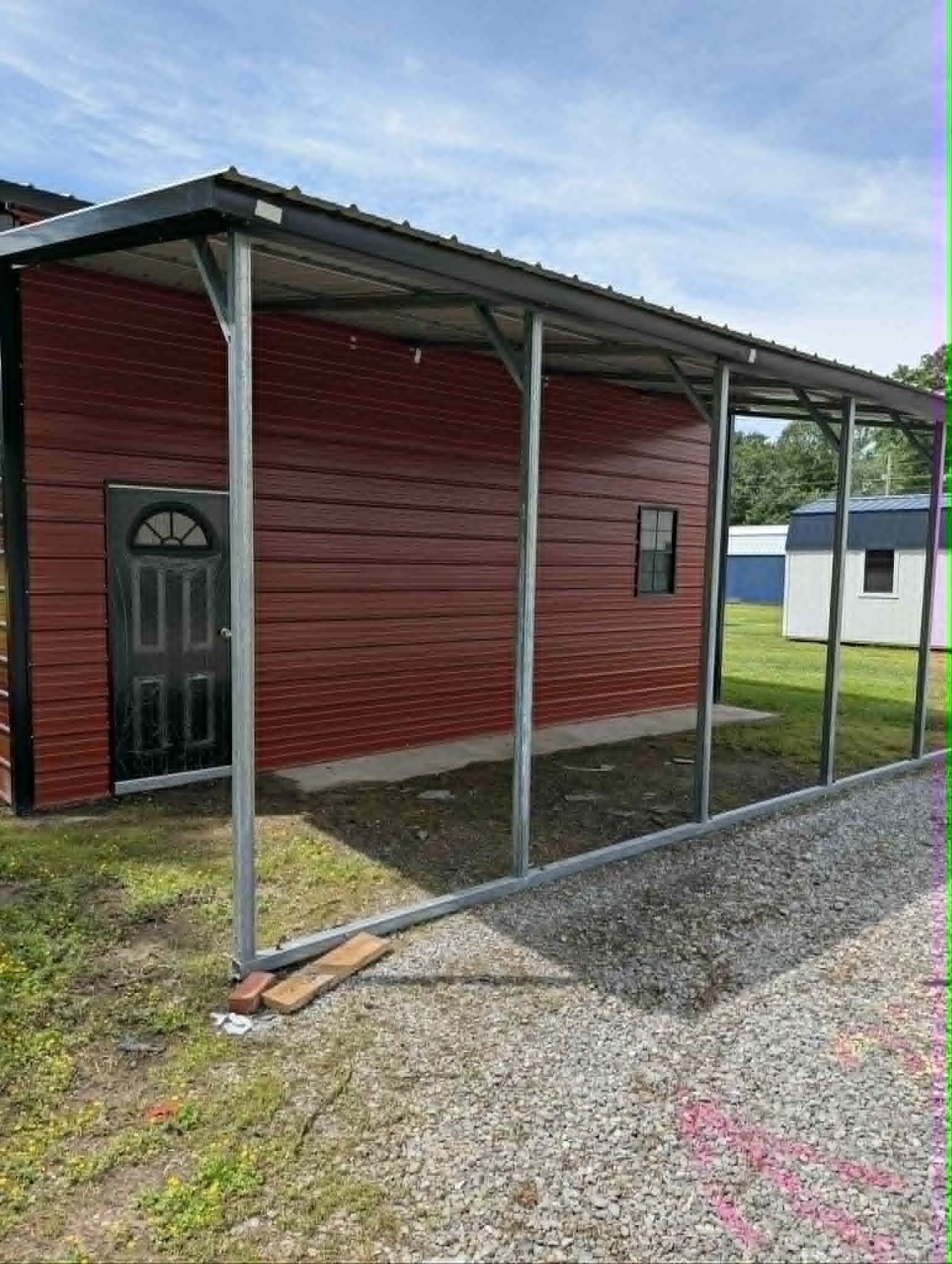 Red steel building with a covered lean-to