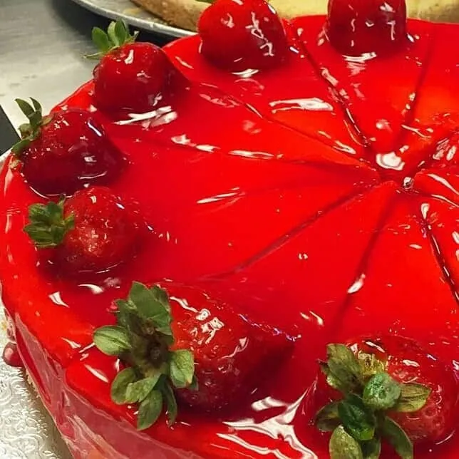 Fresh strawberries arranged beside cheesecake