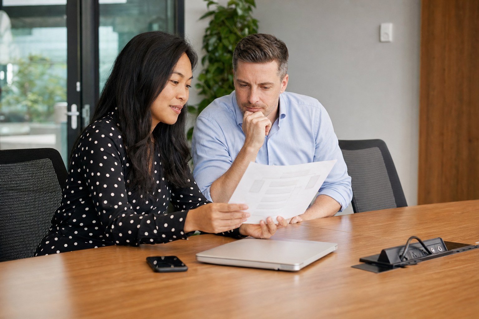 Two coworkers reviewing an incident response plan in an office