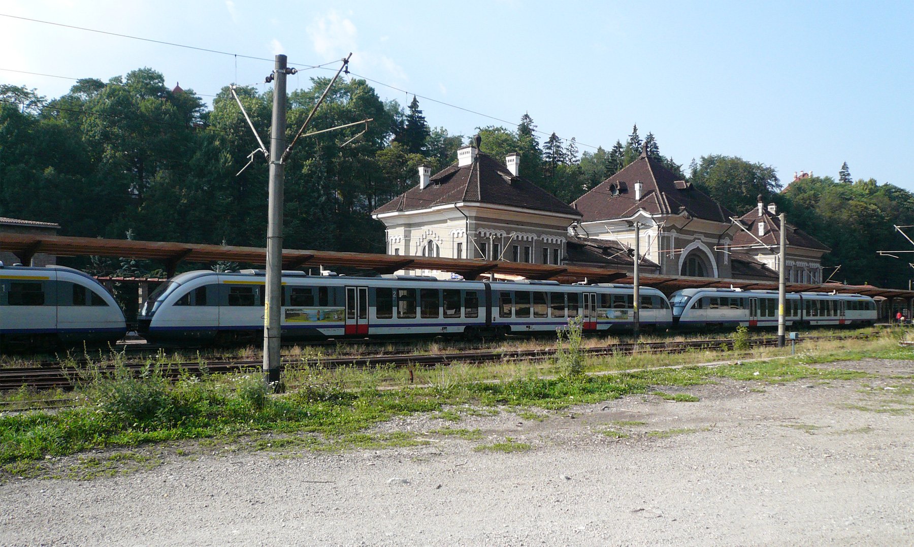 Siemens Desiro passenger trains at Sinaia station with lush green trees behind them