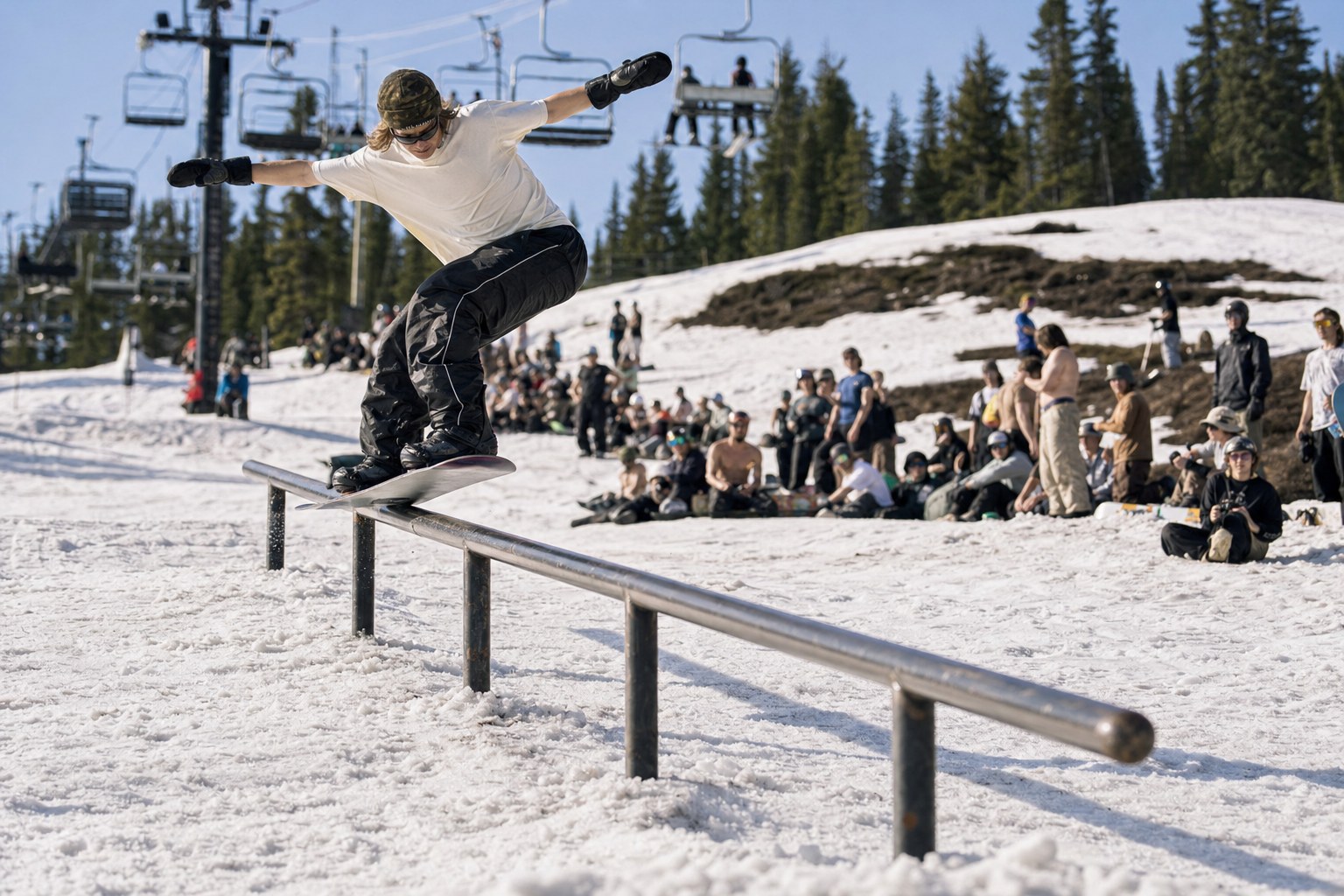 Snowboarder sliding a rail at a spring terrain park jam
