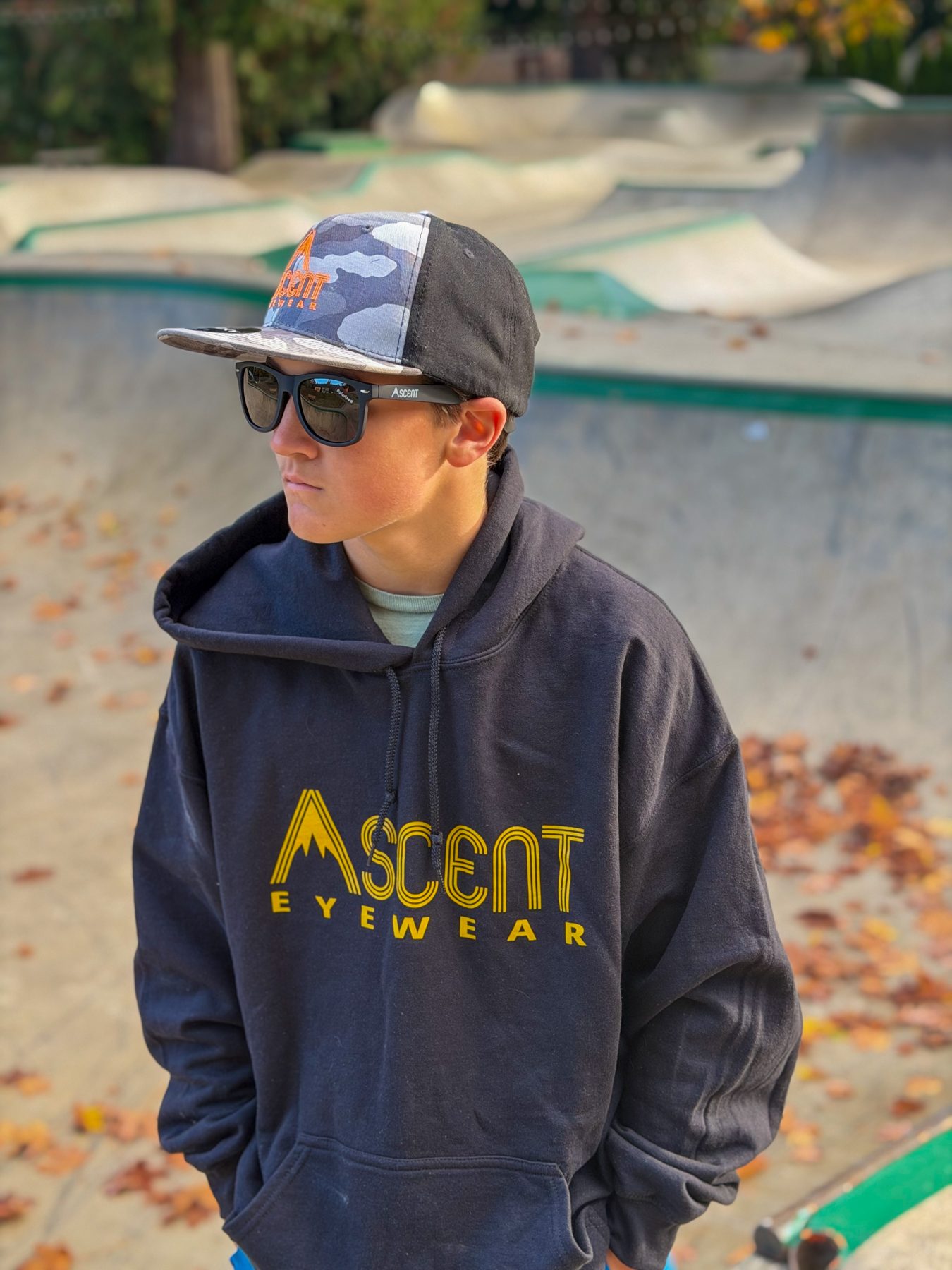 Bear wearing Ascent sunglasses, a cap and hoodie at the skatepark