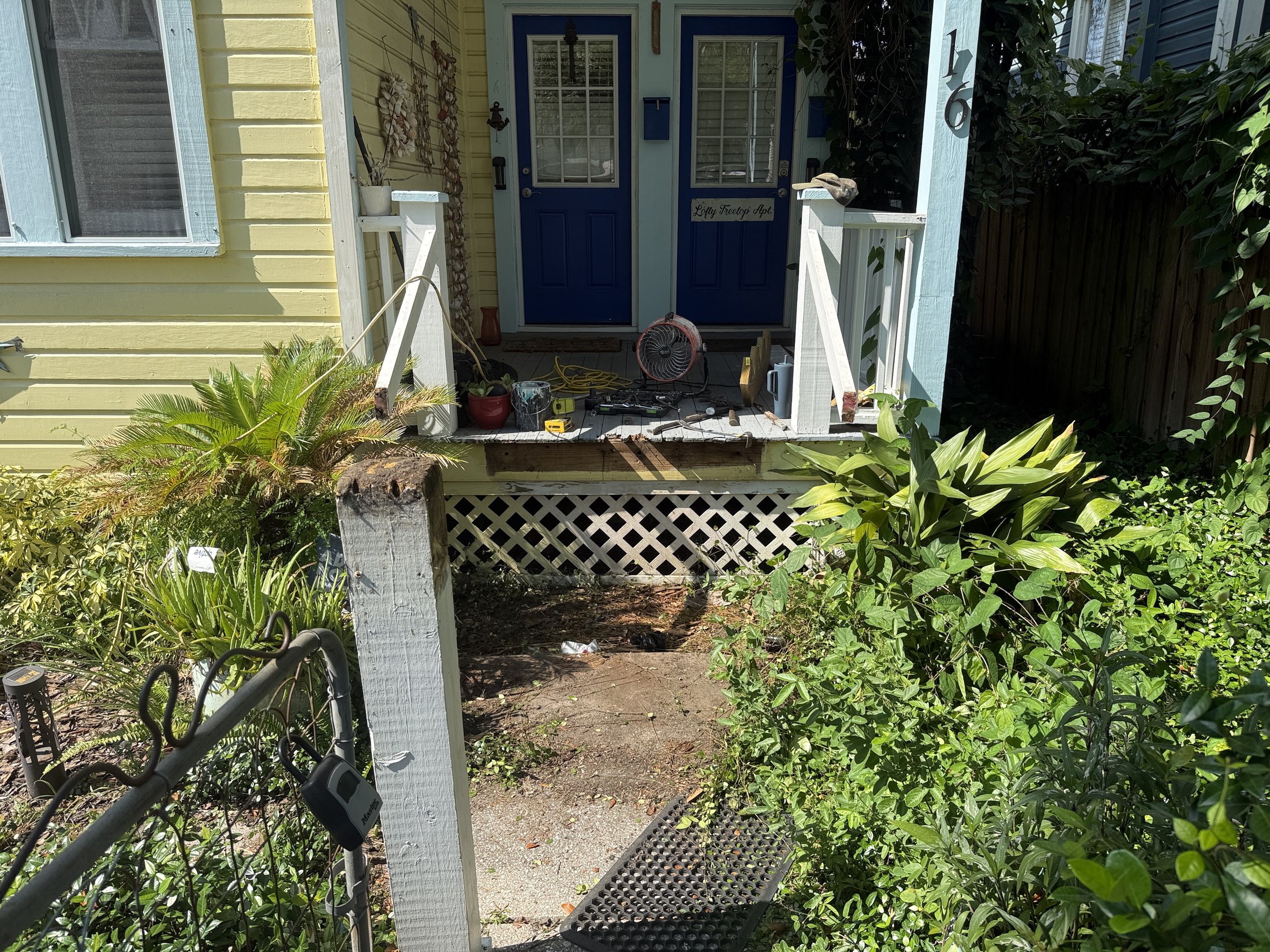 Historic St. Augustine entry before restoration, with damaged steps and porch railings