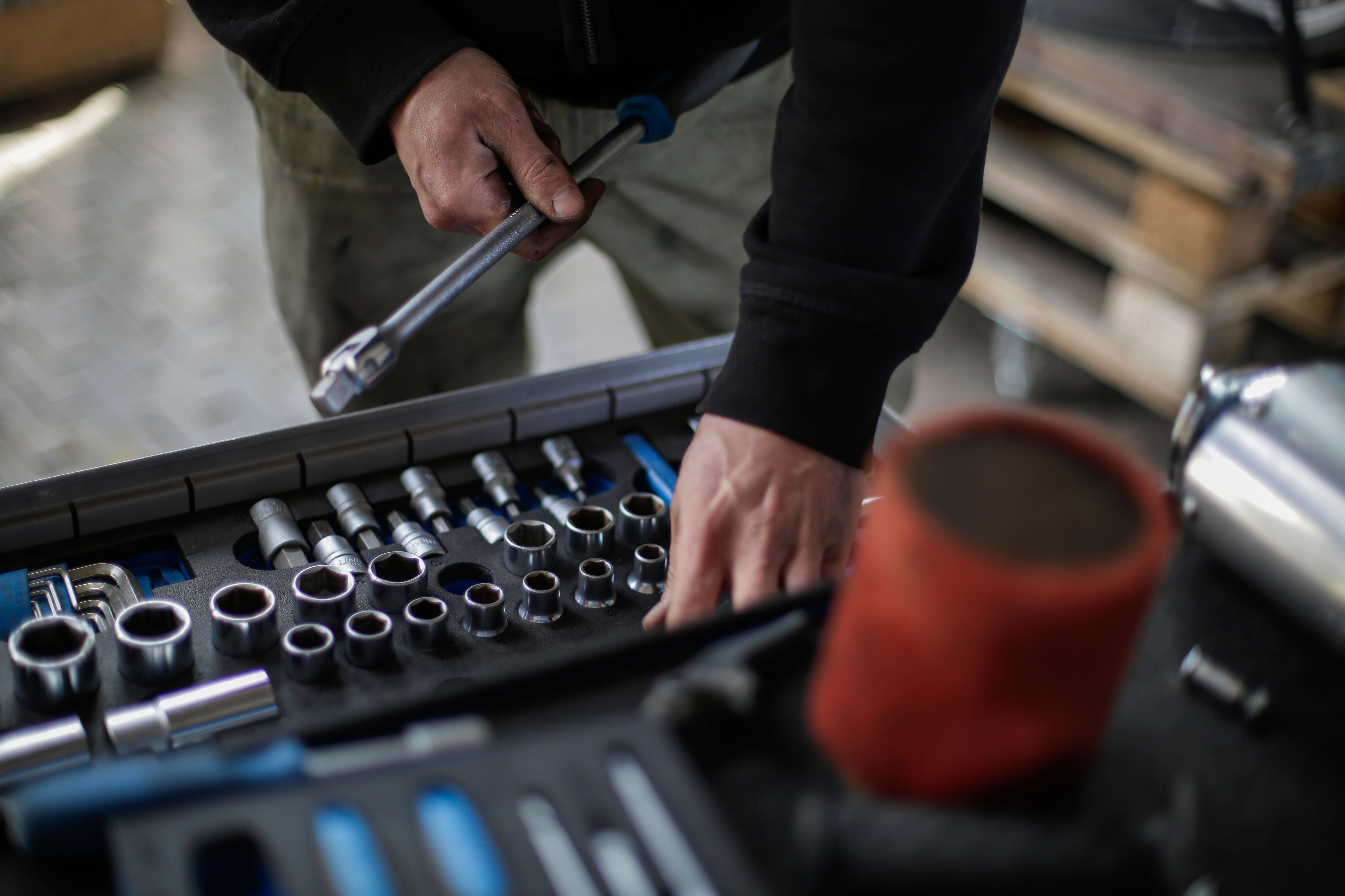 Mechanic selecting sockets and a ratchet from a toolkit