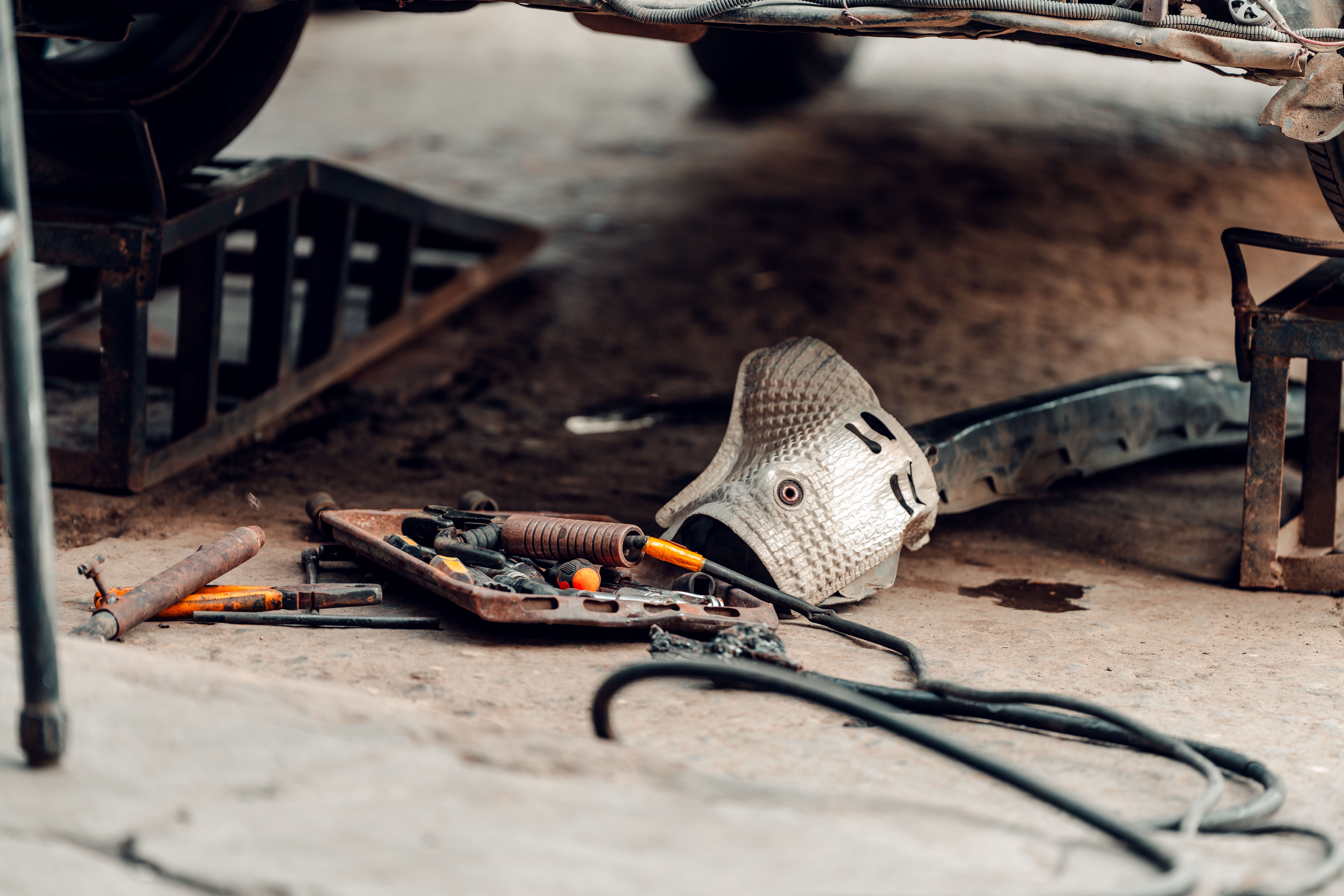 Tools arranged beneath a vehicle supported for garage service
