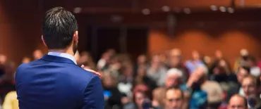 A speaker addressing an audience at a conference