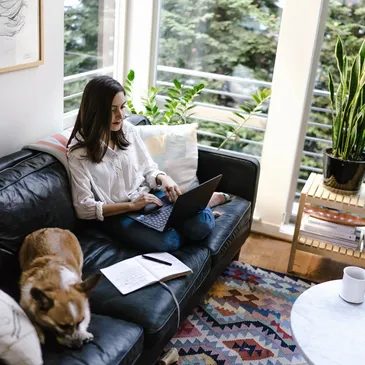 A person studying with a laptop and notes at home