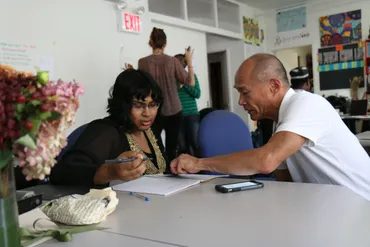 Two people working through study materials together