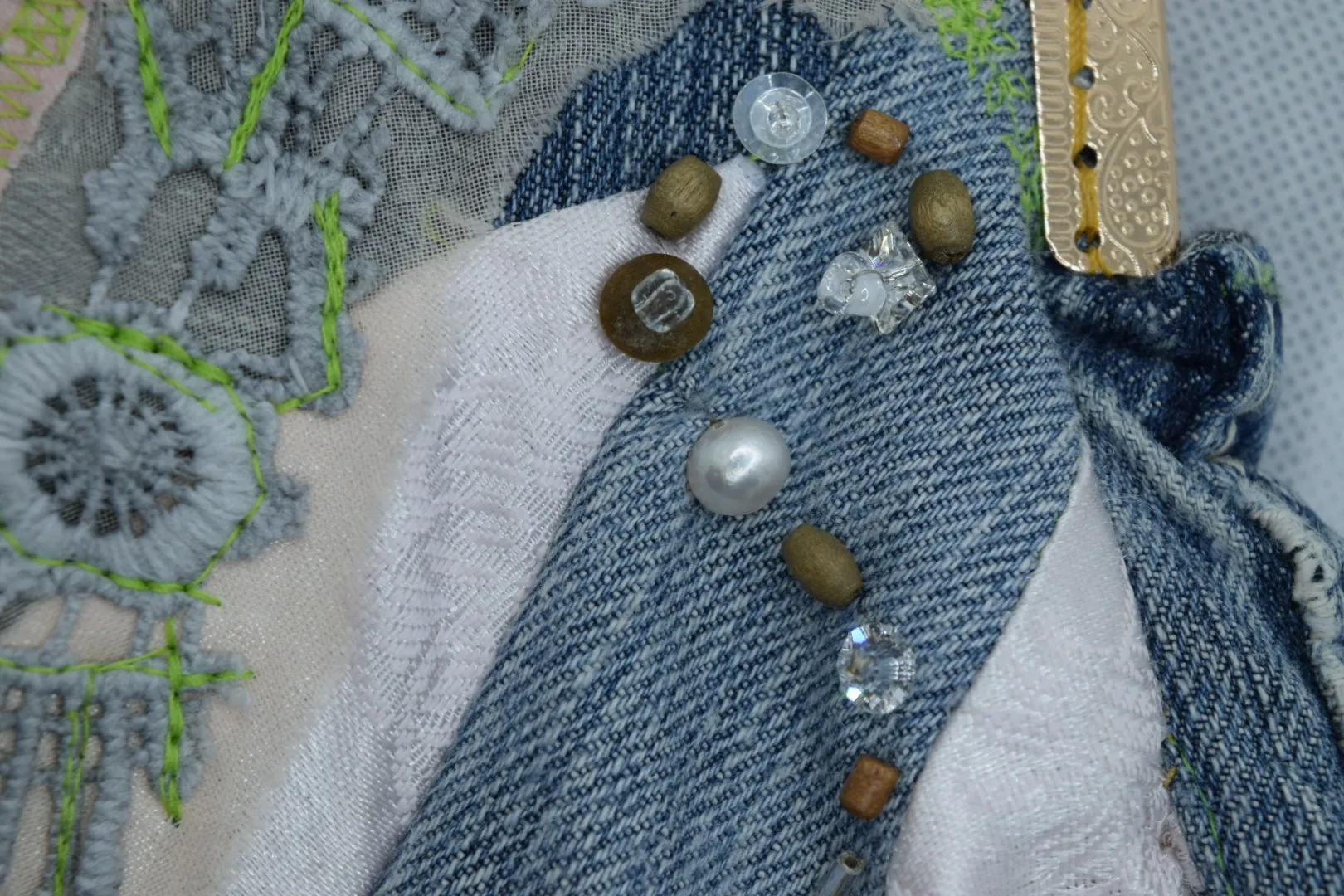 Close view of denim, lace, and embellishment on a Piñon Mesa Atelier piece