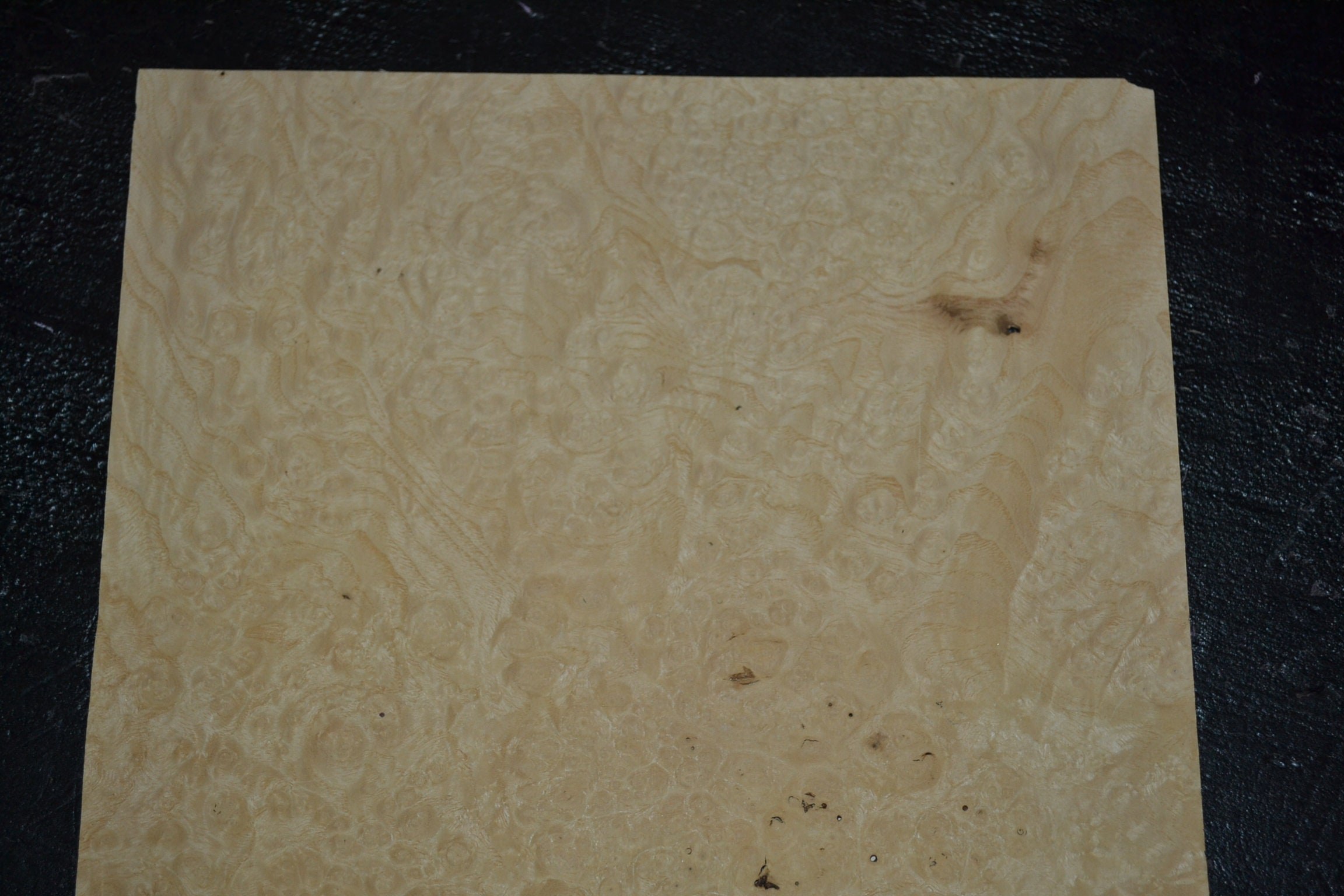 Raw wood veneer sheet showing dramatic figured grain