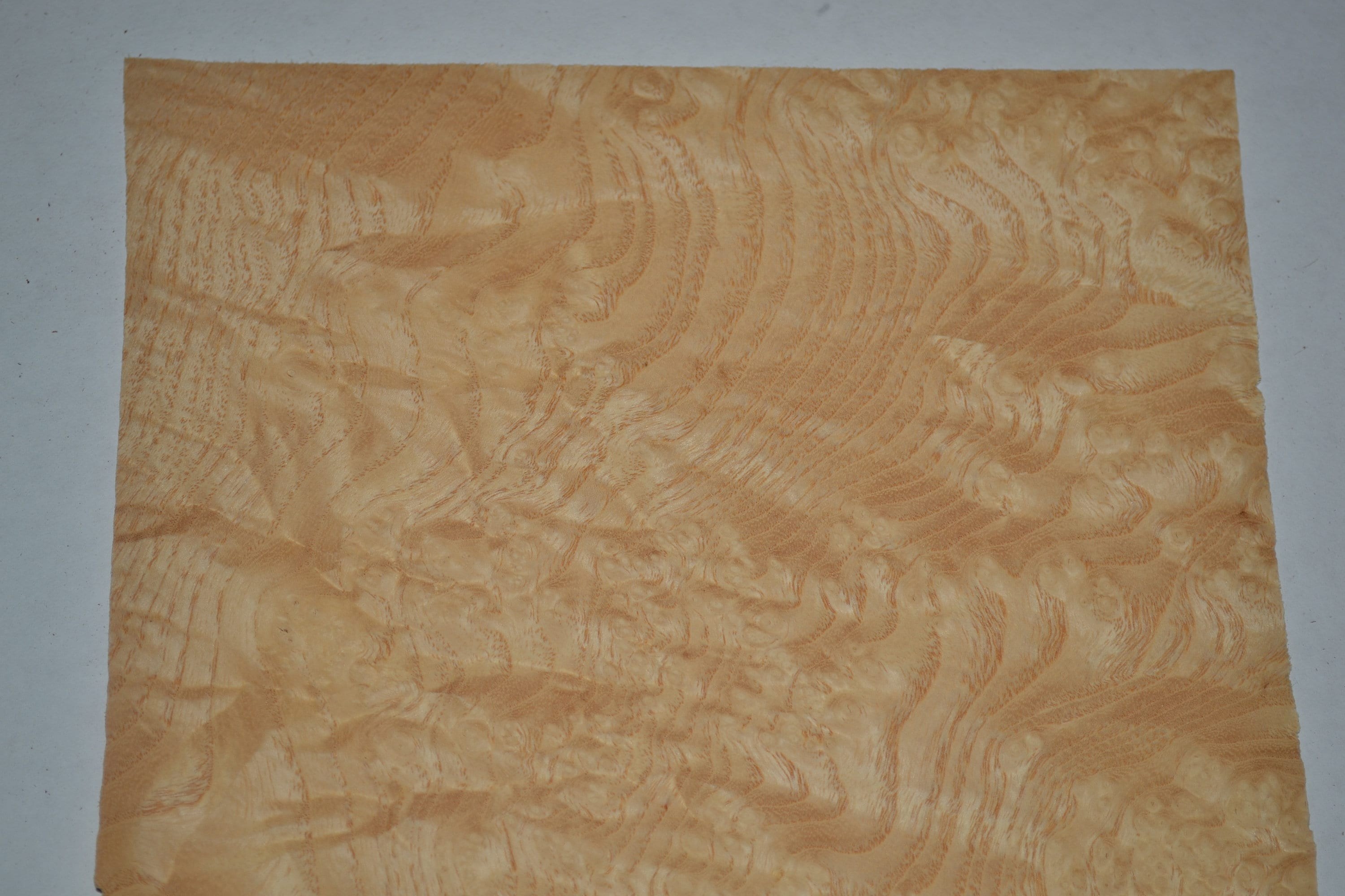 Raw wood veneer sheet with a warm brown figured grain